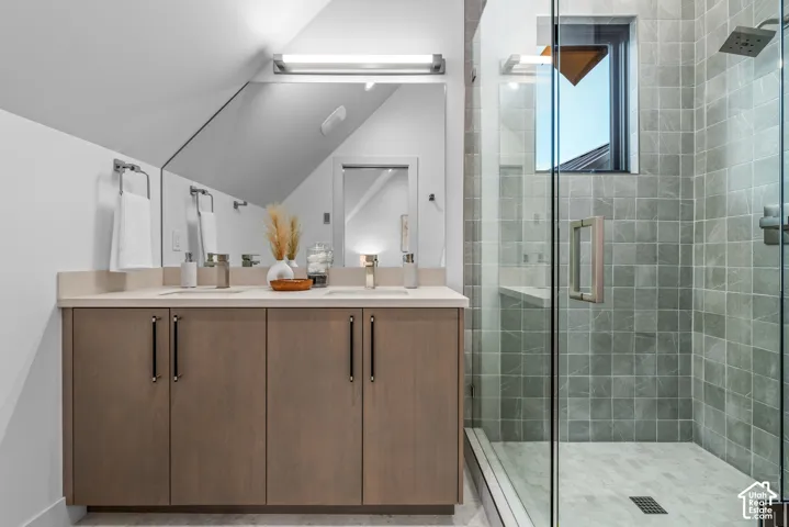 Bathroom featuring a dual-sink vanity with light-toned cabinetry and a light countertop