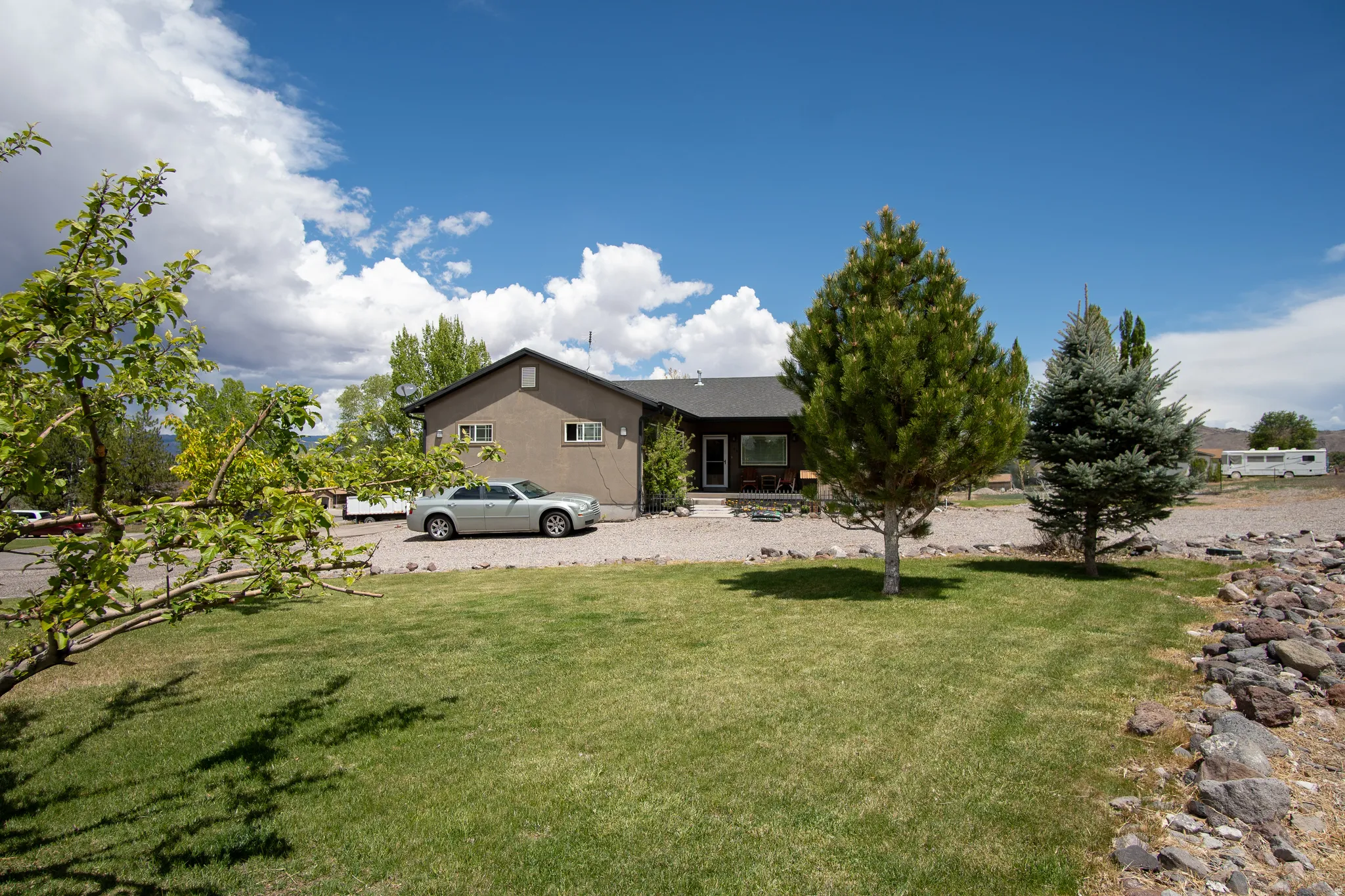 Split-level residence featuring a stucco exterior and gabled roofline