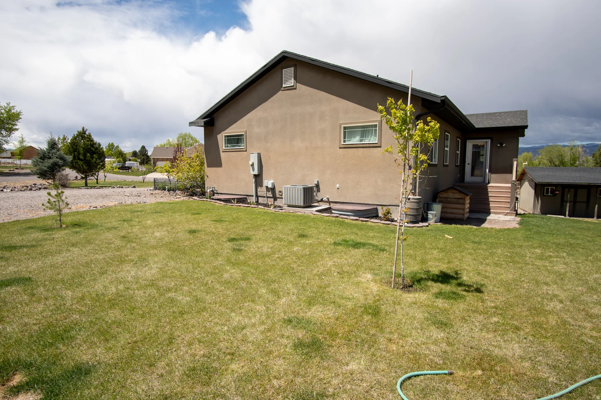 Expansive lawn area surrounding a stucco exterior residence