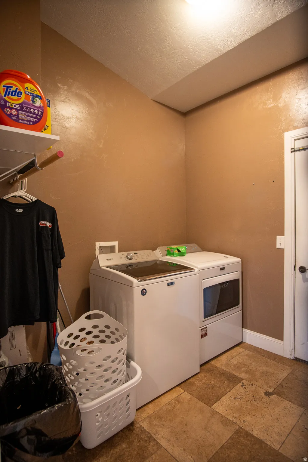 Dedicated laundry area featuring durable tiled flooring and neutral wall tones