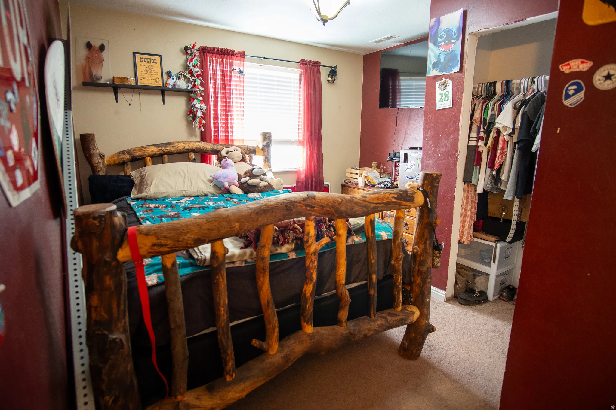 Carpeted room with a ceiling light fixture, window with blinds, and an open closet