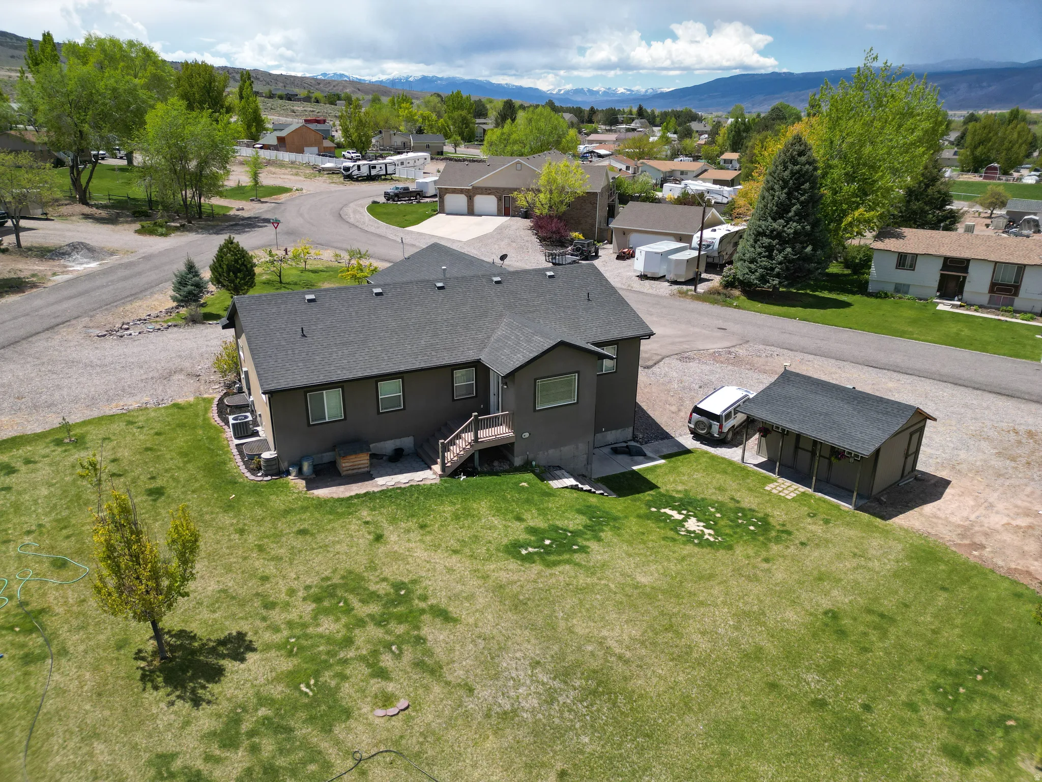 Spacious rear yard with green lawn and mature trees