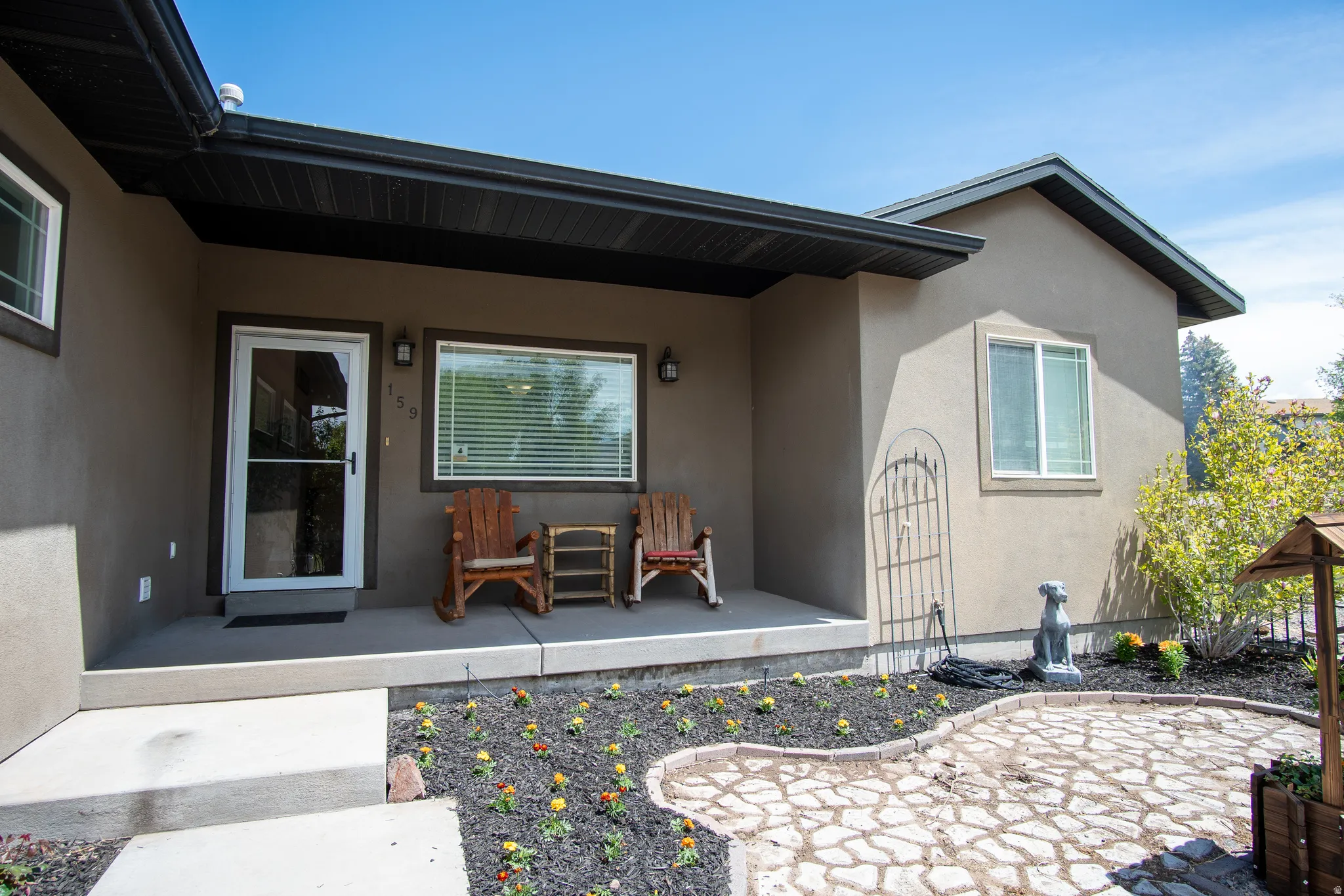 Stucco exterior featuring a covered entry porch with recessed lighting