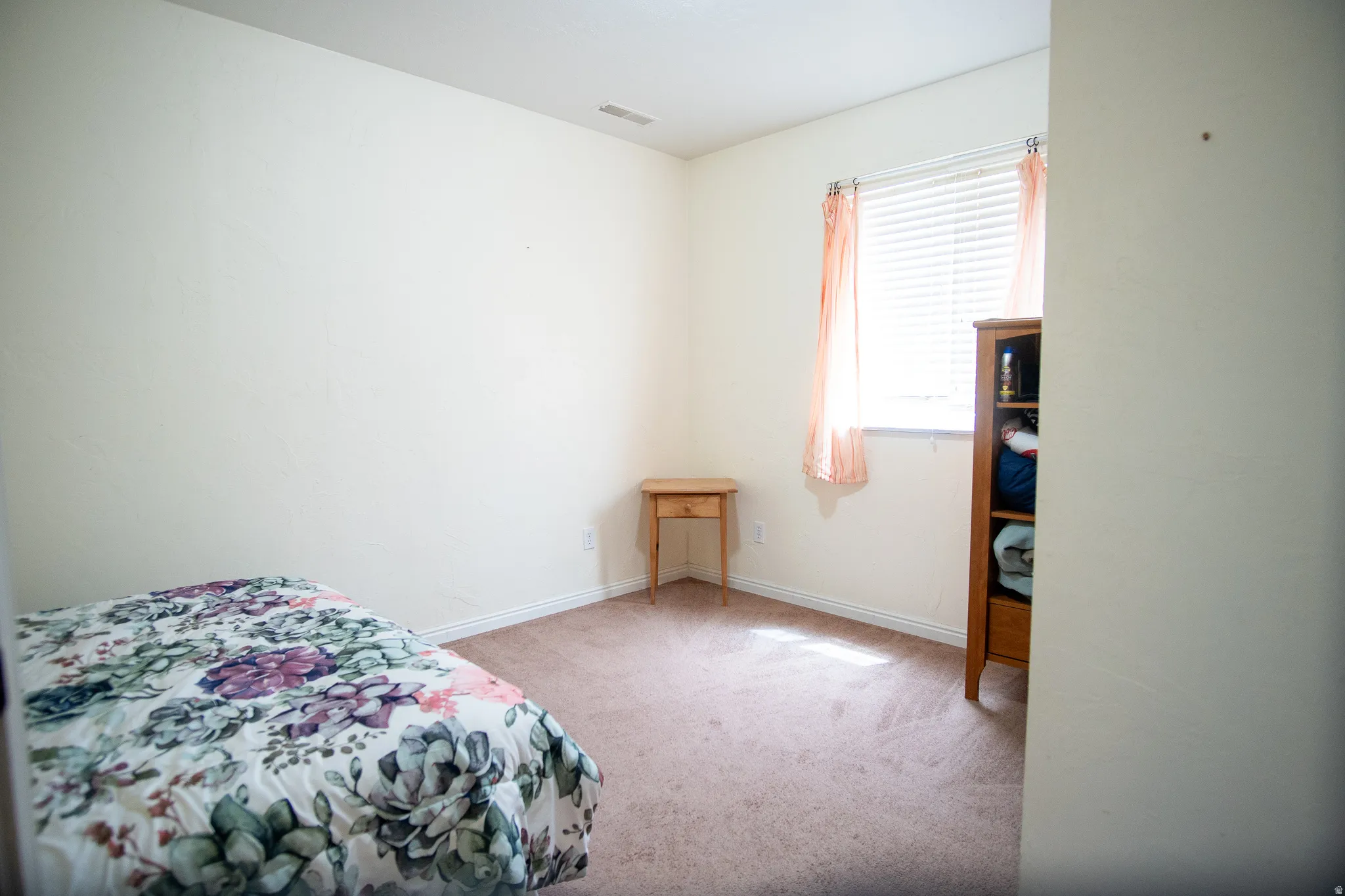 Carpeted room featuring a window with blinds, baseboards, and a ceiling vent