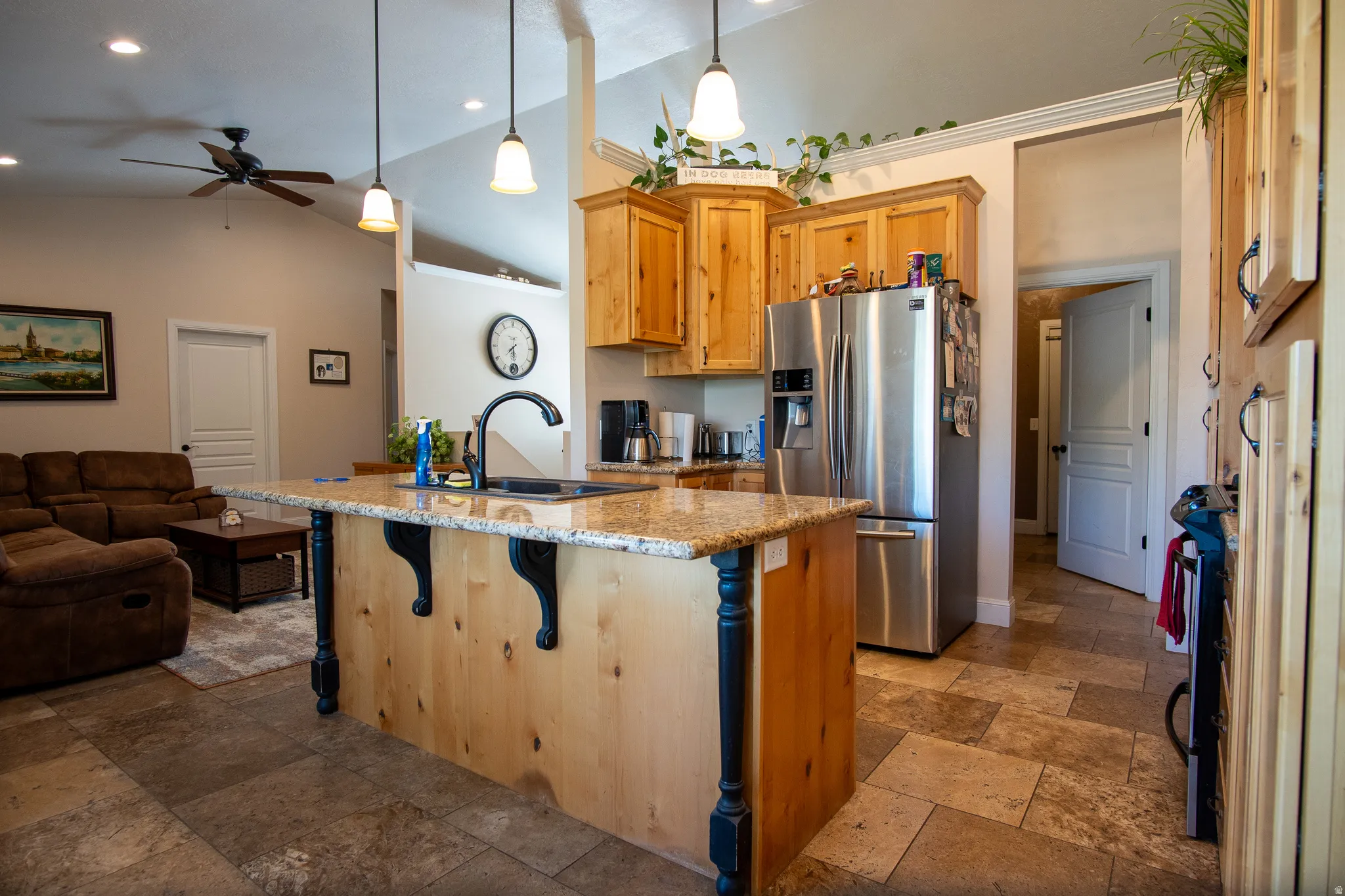 Kitchen island featuring a granite countertop with an undermount sink and black faucet