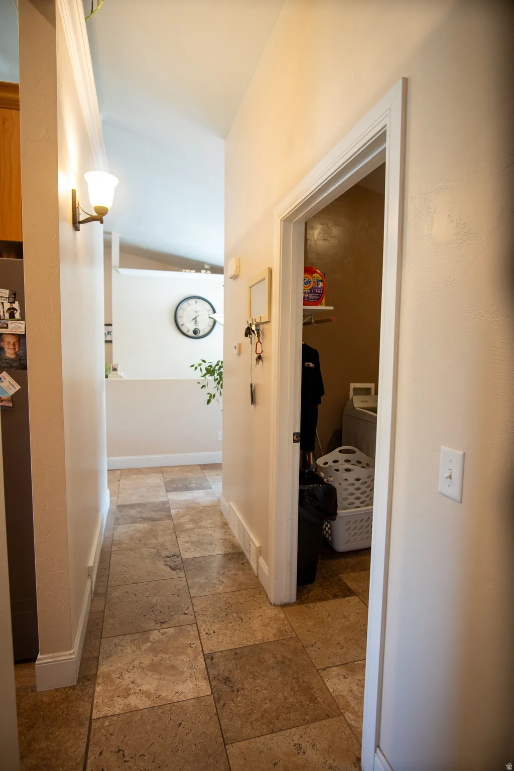 Hallway featuring large format stone tile flooring, neutral wall tones, and recessed lighting