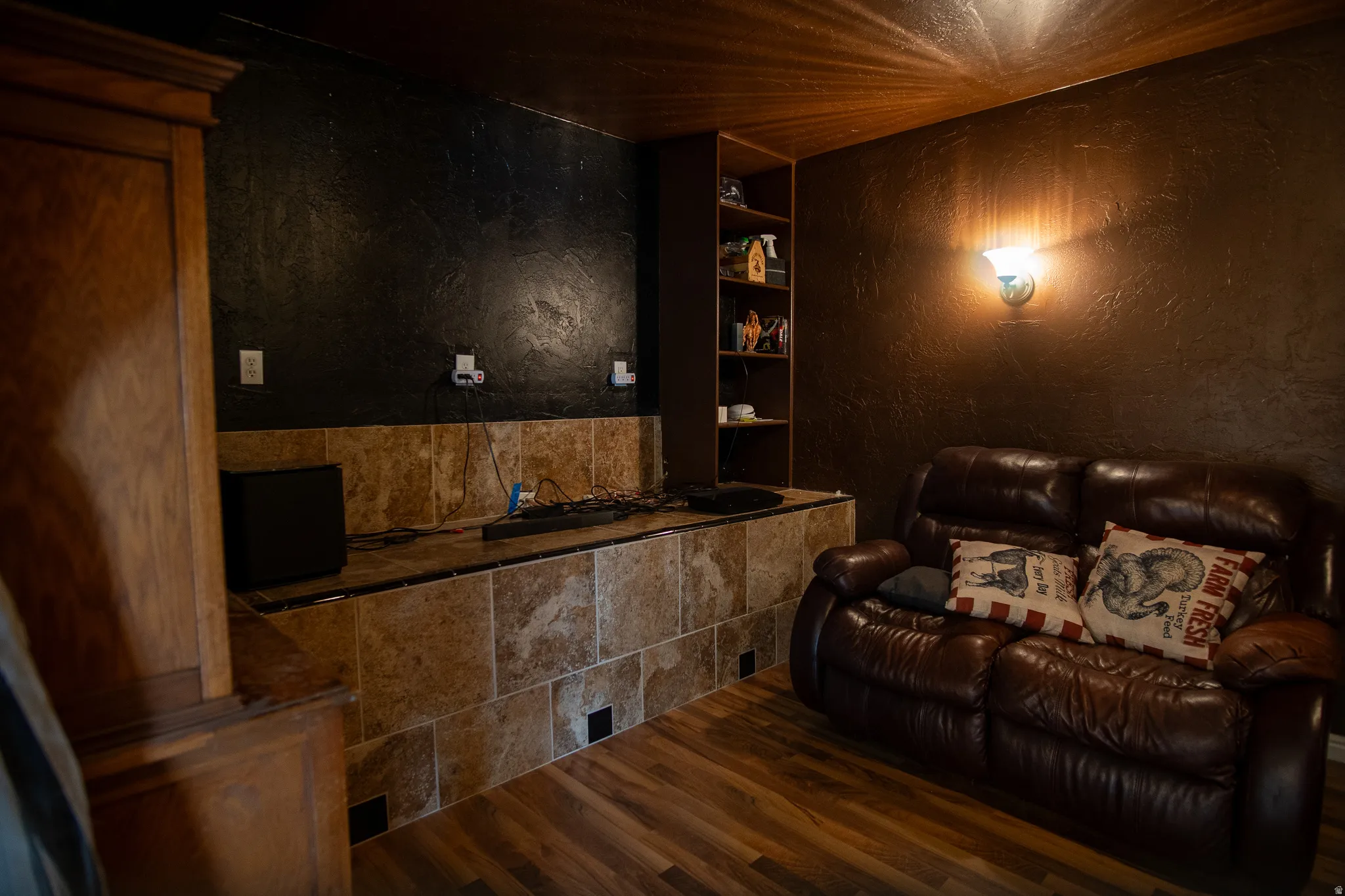 Entertainment space featuring wood-finish flooring and a tile-faced half-wall