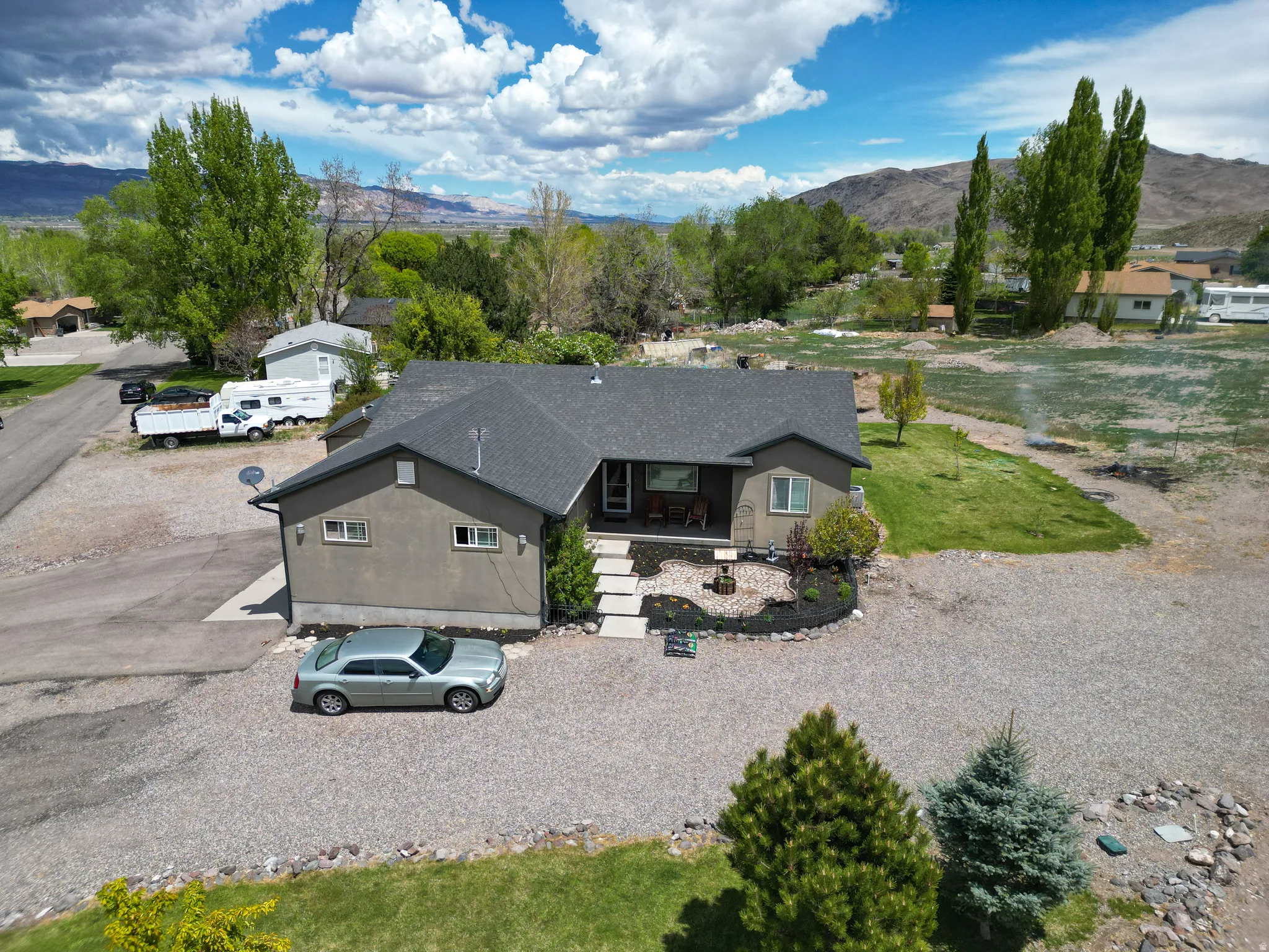 Single-story residence featuring a dark gray roof and light brown stucco exterior