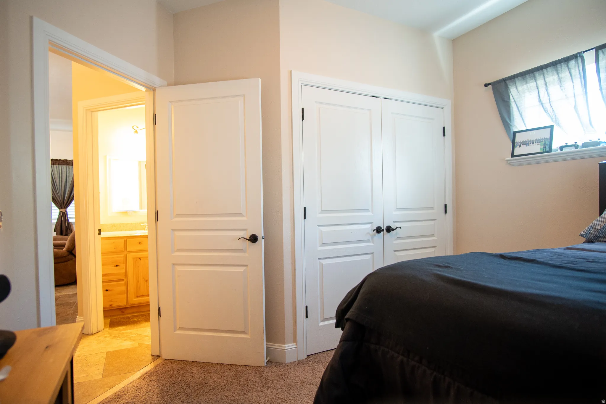 Bedroom featuring carpet flooring, crisp white trim, and a window with a simple rod