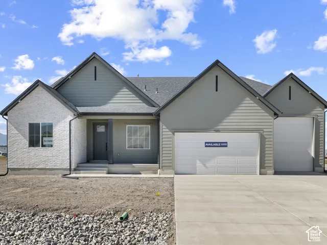 Single-level exterior featuring white brick masonry, horizontal siding, multiple gables, a covered entry, and a three-car garage
