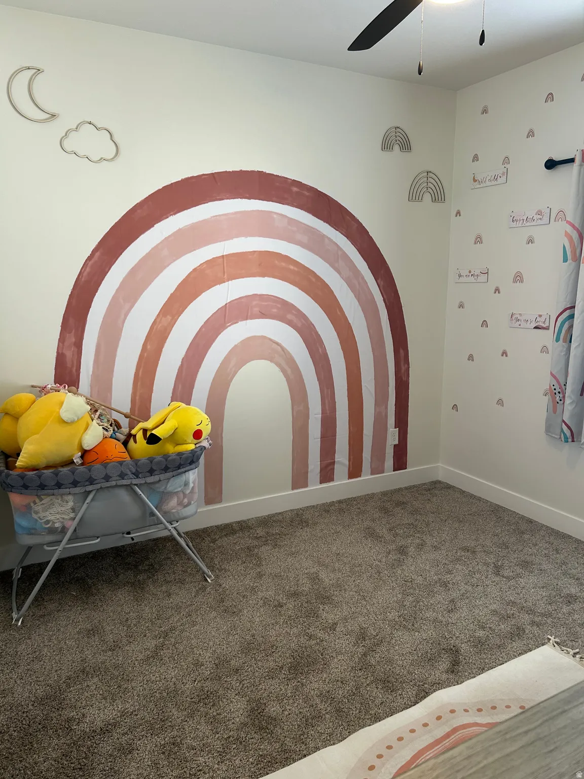 Neutral wall color with a decorative rainbow mural