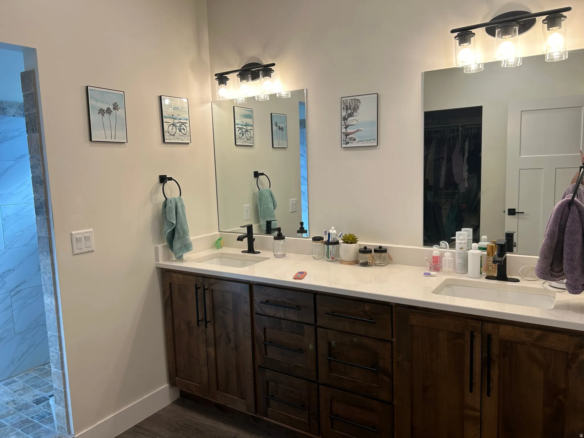 Double vanity with rich wood-finish cabinetry and white countertops