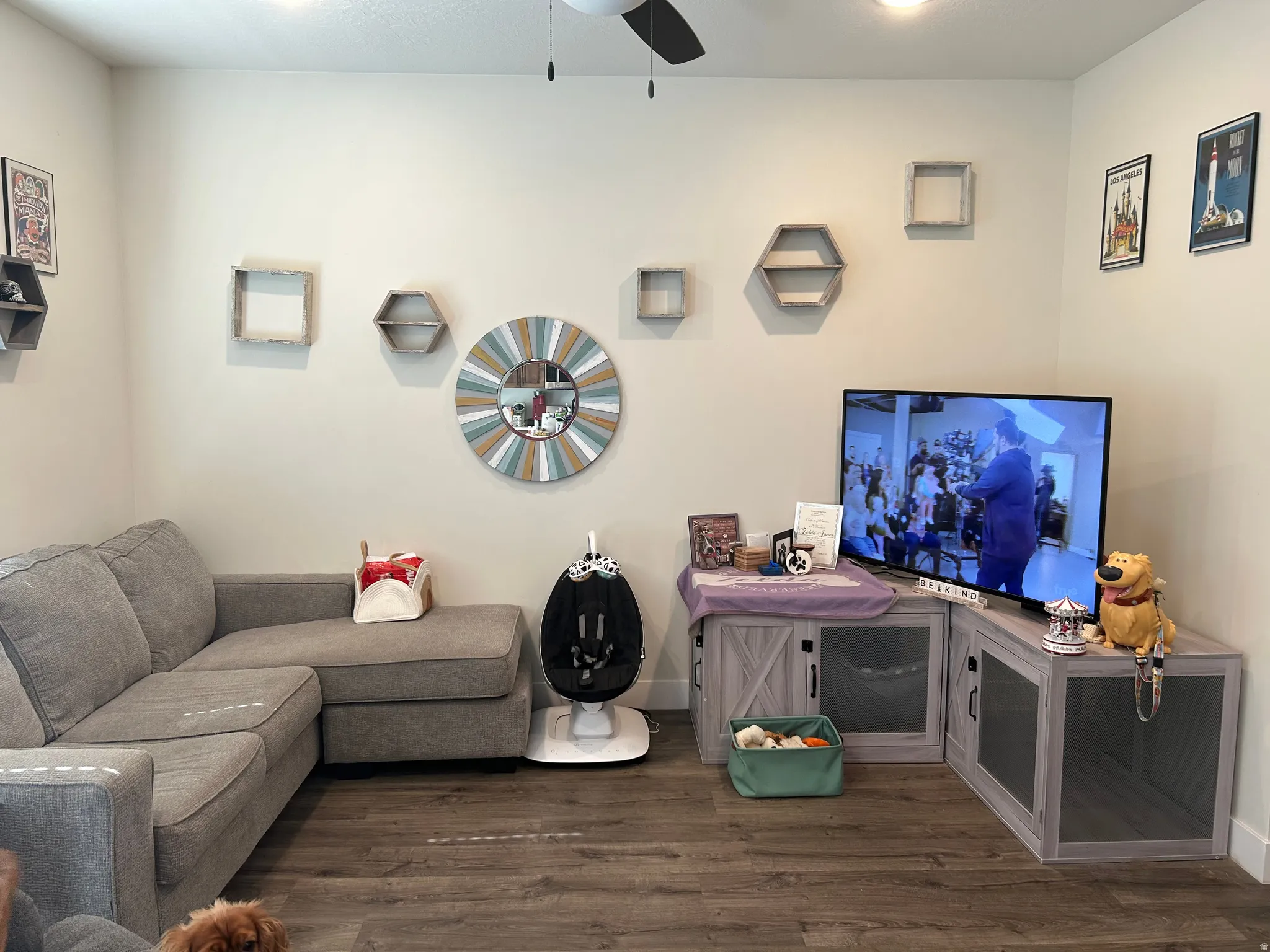 Living space featuring wood-finish flooring, a ceiling fan with integrated lighting, and neutral wall tones
