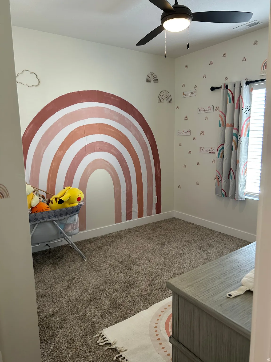 Carpeted room featuring a ceiling fan with integrated lighting, a window with blinds, and white baseboards