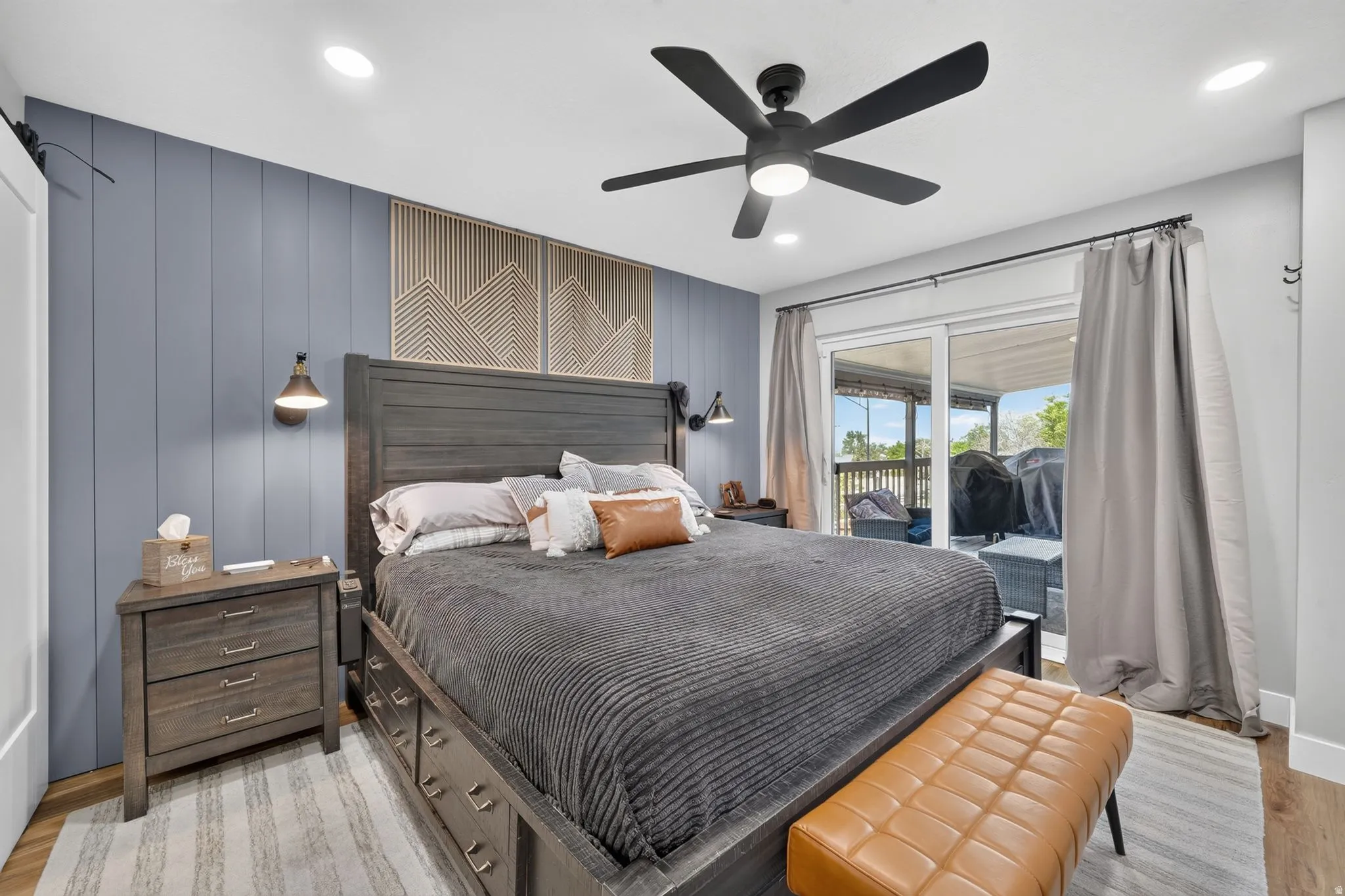 Spacious room featuring a blue accent wall with vertical paneling, recessed lighting, and a ceiling fan