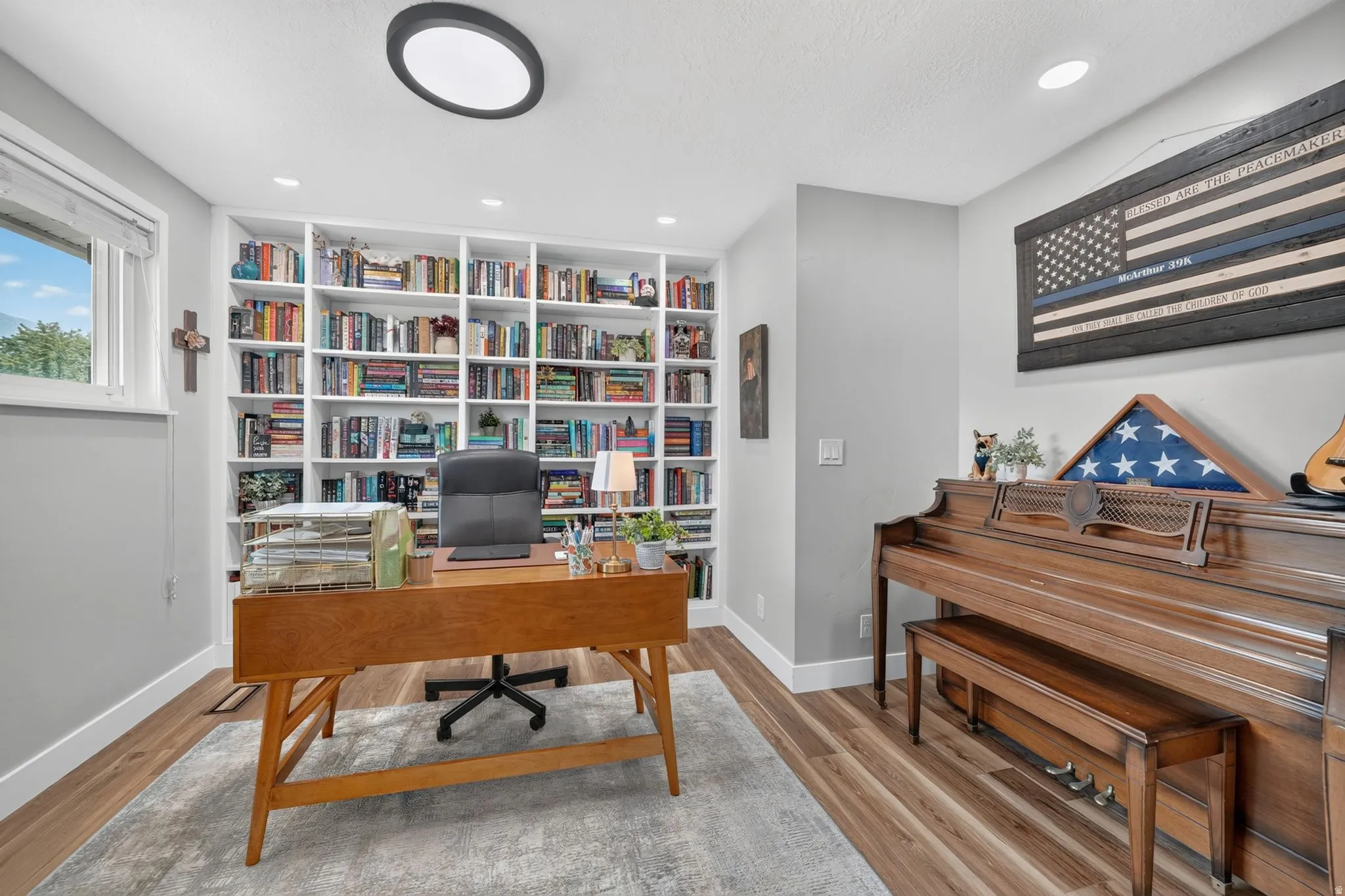 Floor-to-ceiling custom built-in shelving, recessed ceiling lighting, and a window providing natural light