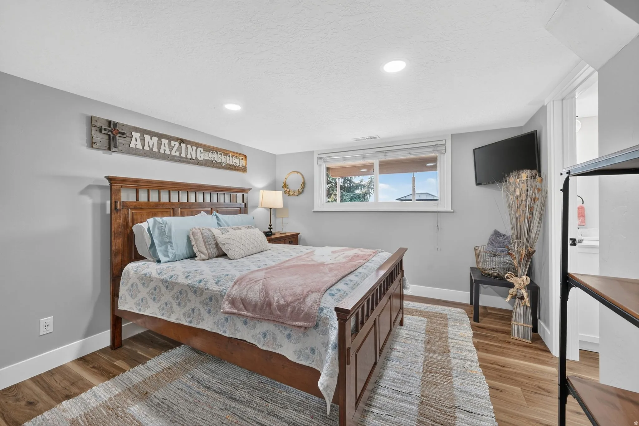 Bedroom with wood-finish flooring, recessed lighting, and a window with blinds