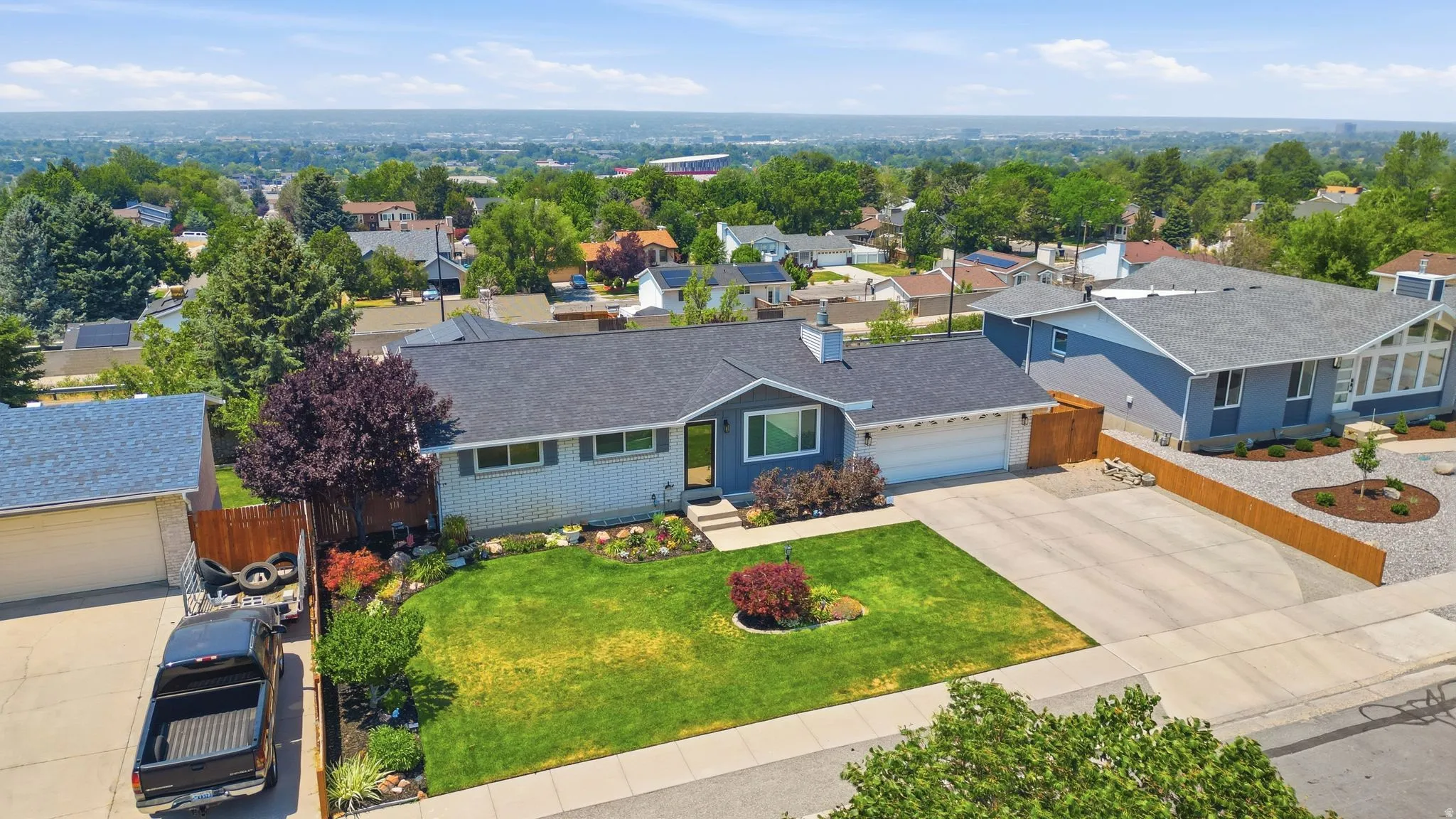 Single-story home featuring a grey shingle roof, blue siding, and white brick detailing