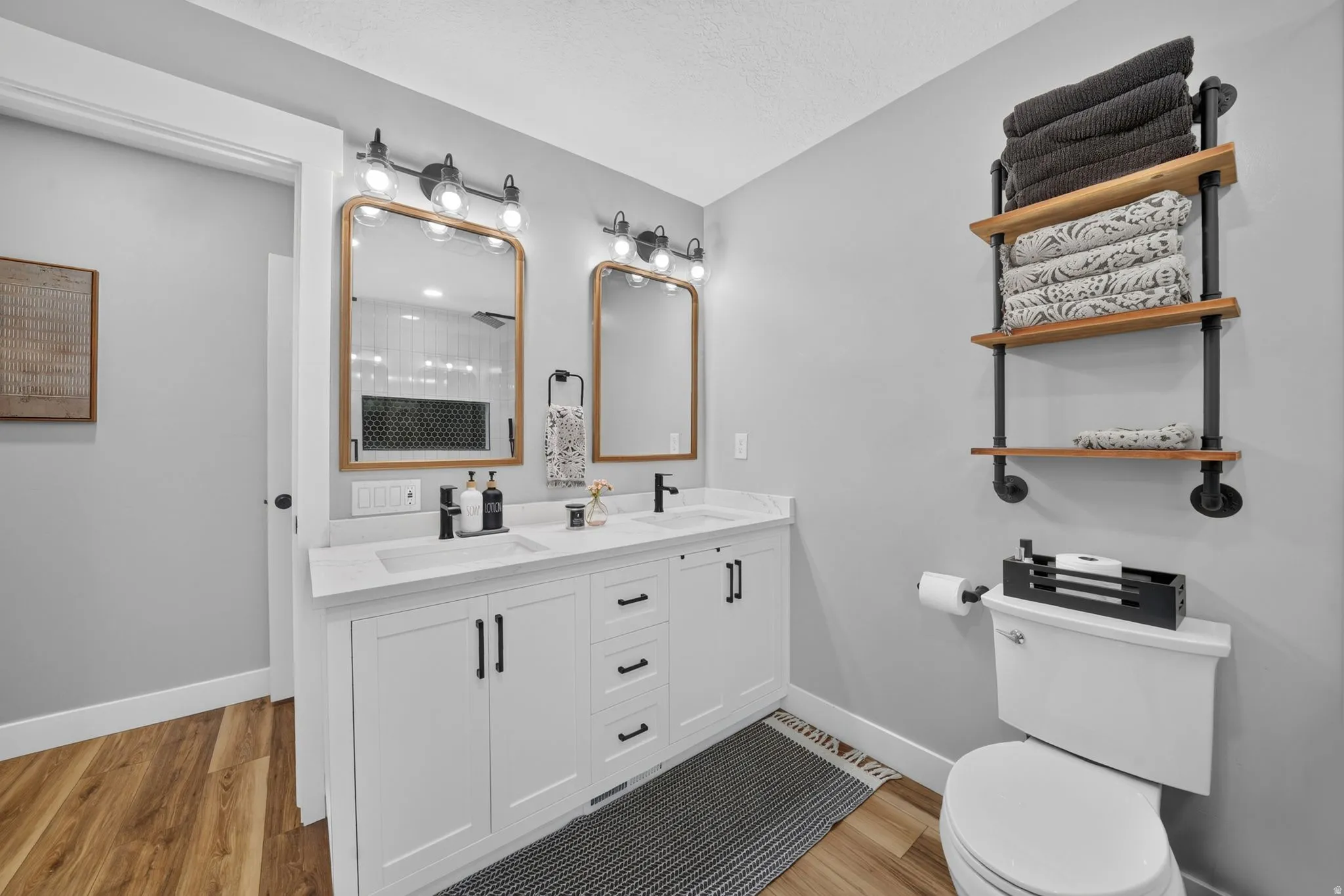 Dual vanity with white cabinetry, quartz-finish countertop, and matte black hardware
