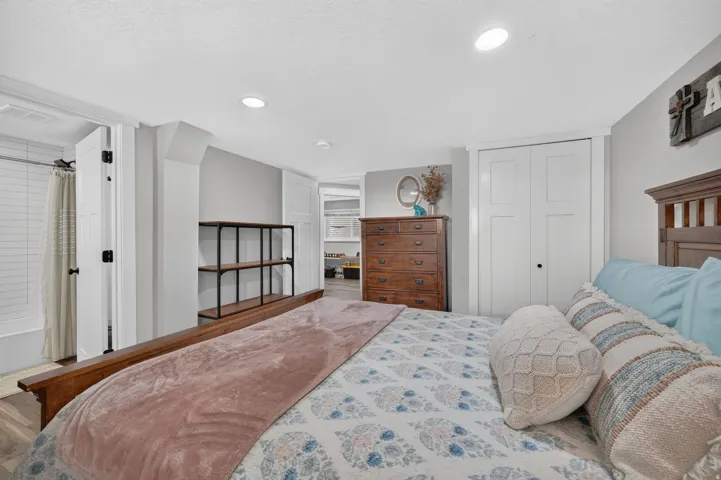 Bedroom featuring wood-finish flooring, recessed lighting, and a built-in shelving unit