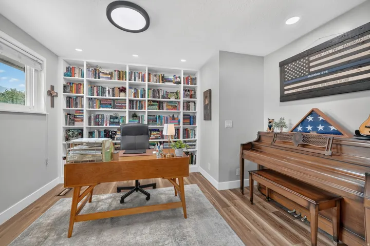 Floor-to-ceiling custom built-in shelving, recessed ceiling lighting, and a window providing natural light
