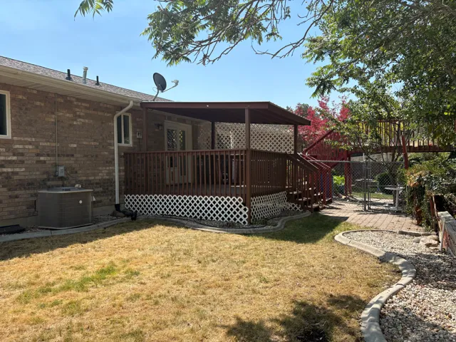 Covered deck with lattice skirting and wood railing