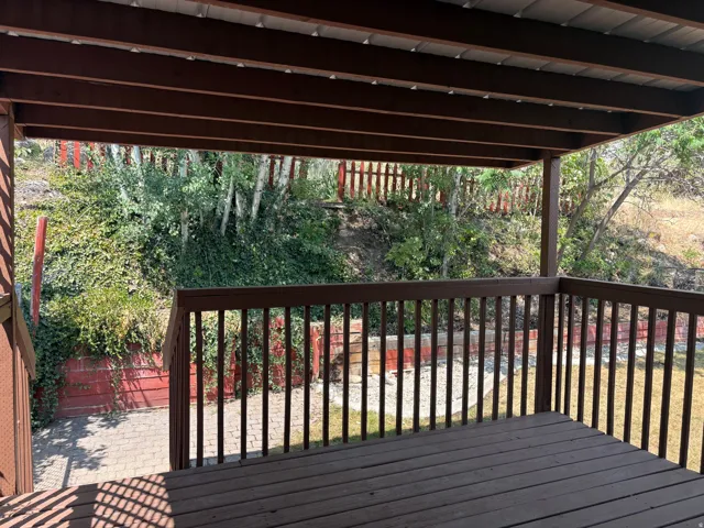 Covered wooden deck with slatted railing, offering outdoor living space