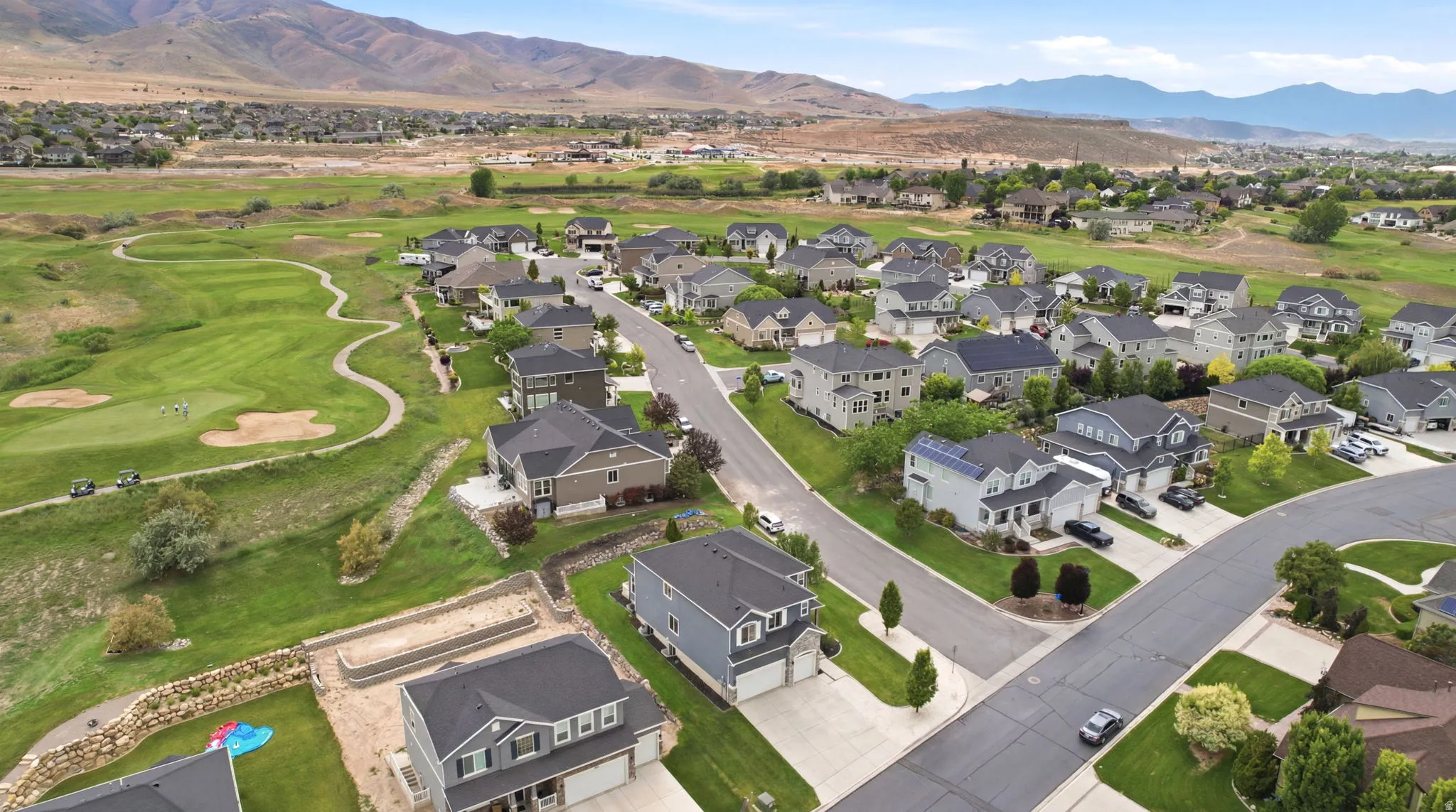 Residential neighborhood with varied architectural styles, manicured lawns, and paved streets