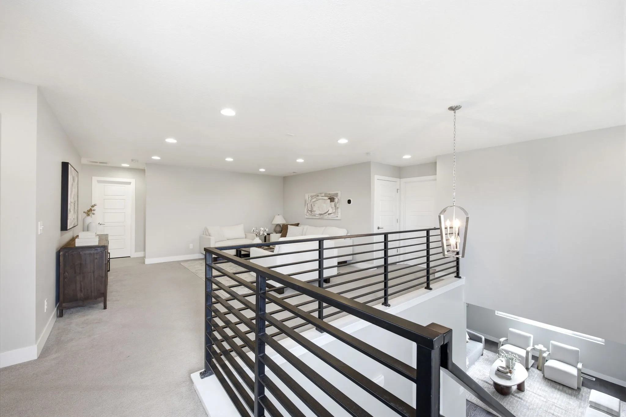 Upper-level loft area with carpet flooring and recessed lighting