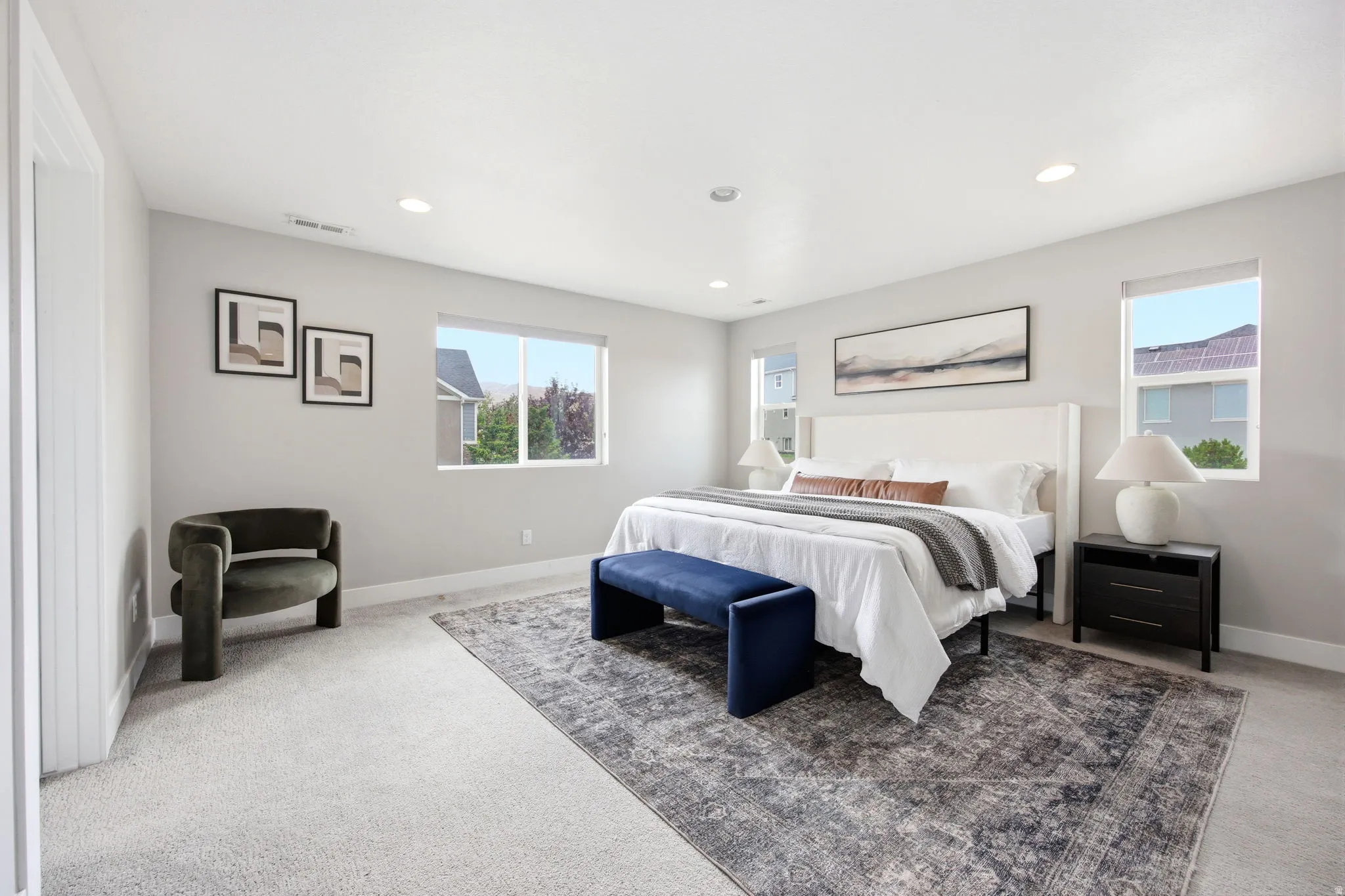 Carpeted bedroom featuring a light gray color palette, recessed lighting, and multiple windows
