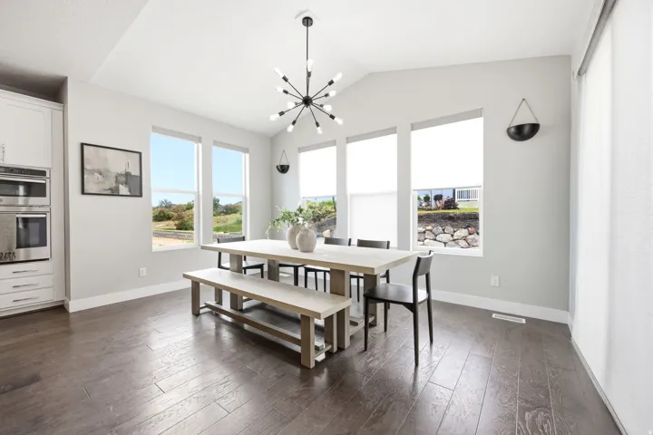 Bright dining area featuring a vaulted ceiling and a modern chandelier