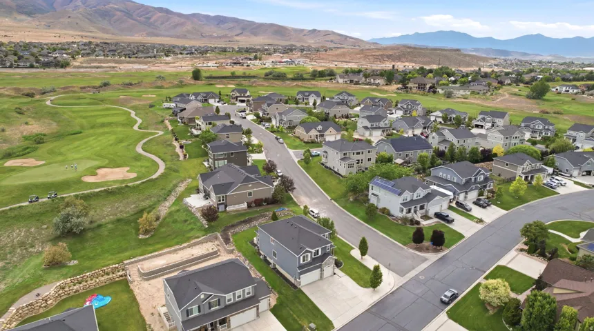 Residential neighborhood with varied architectural styles, manicured lawns, and paved streets