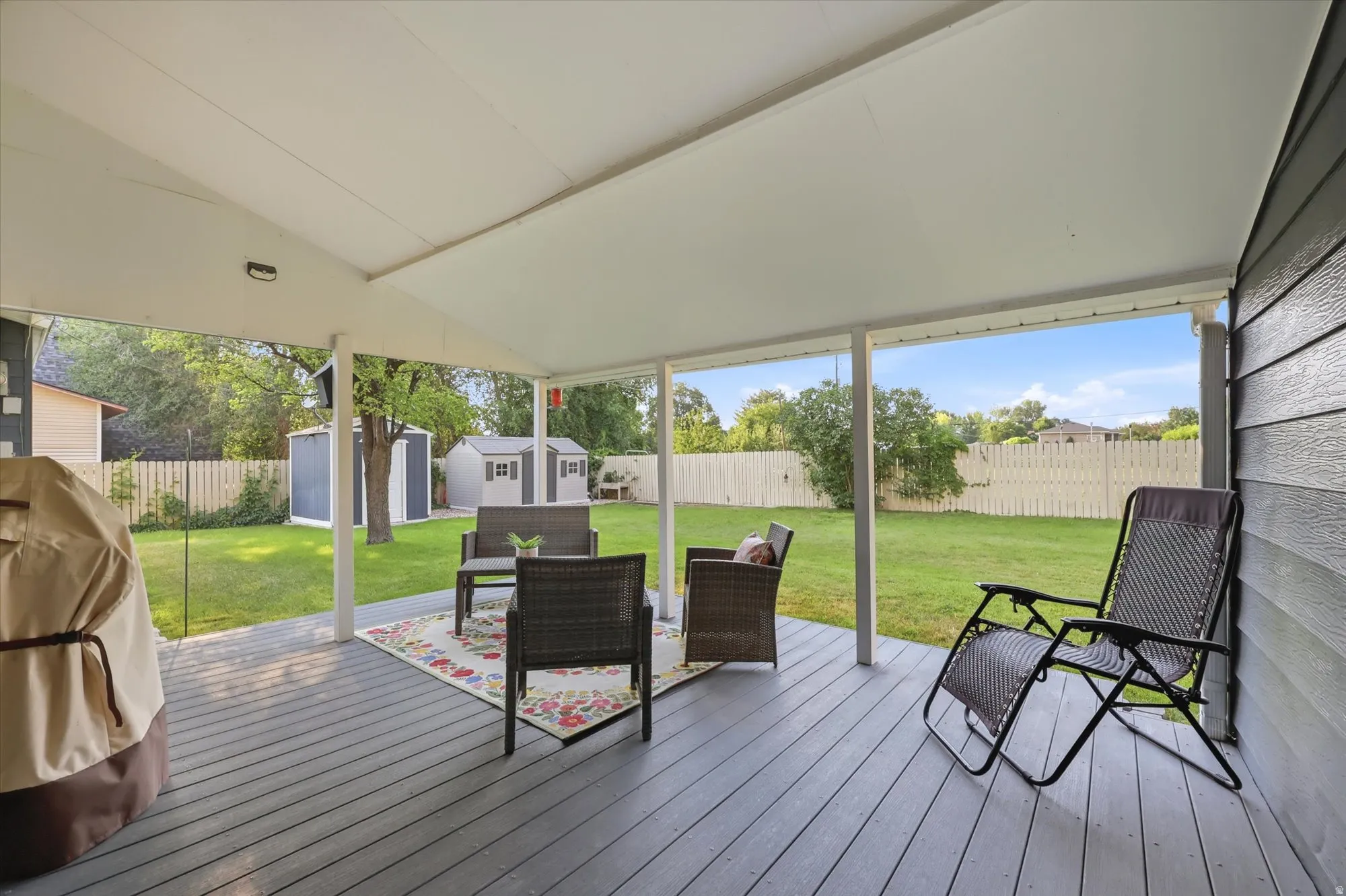 Covered patio featuring a painted wood-finish deck and white support columns