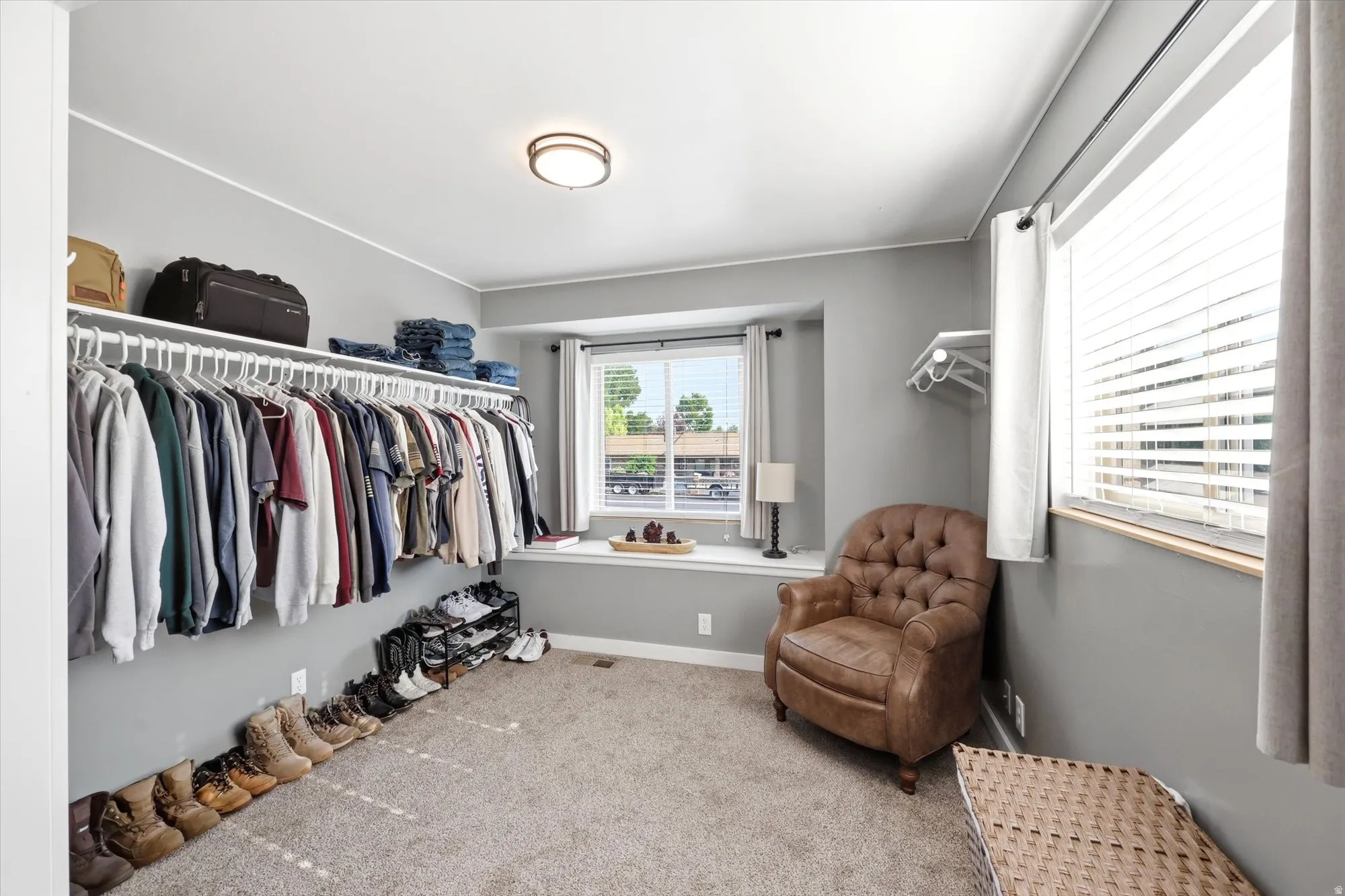 Spacious closet area featuring light gray walls and carpet flooring