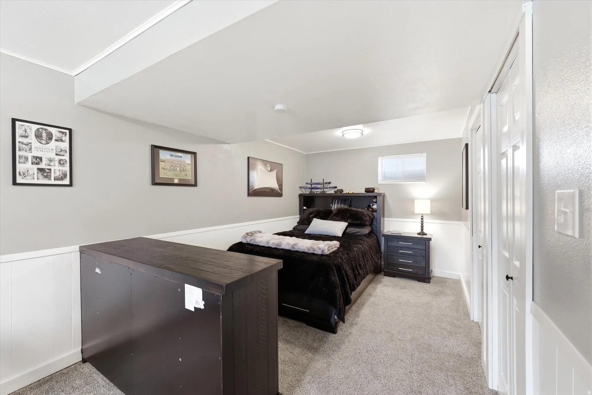 Carpeted room featuring a window, white paneled wainscoting, and white trim