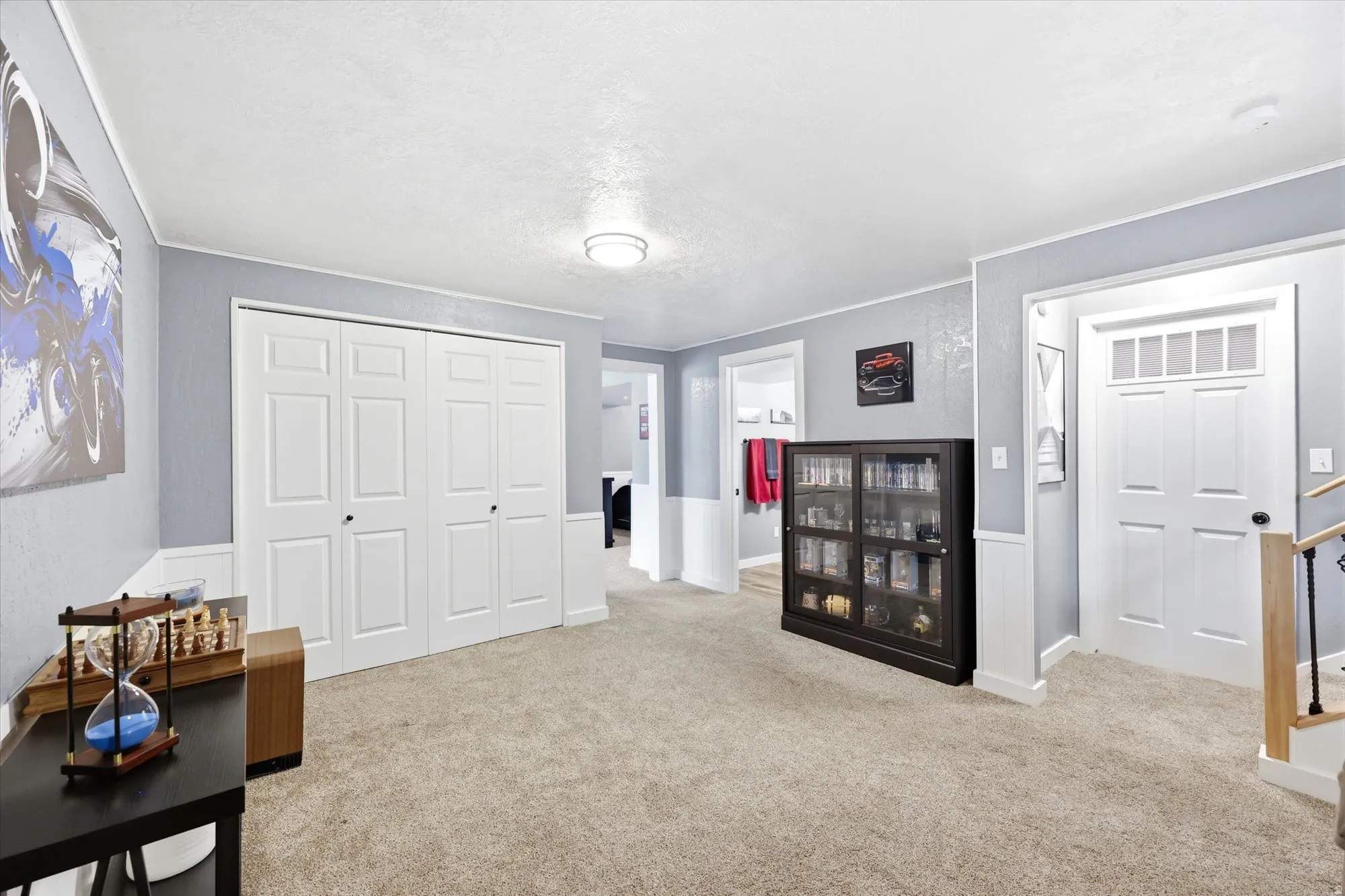 Open concept room with neutral carpeting, light blue walls, and white trim