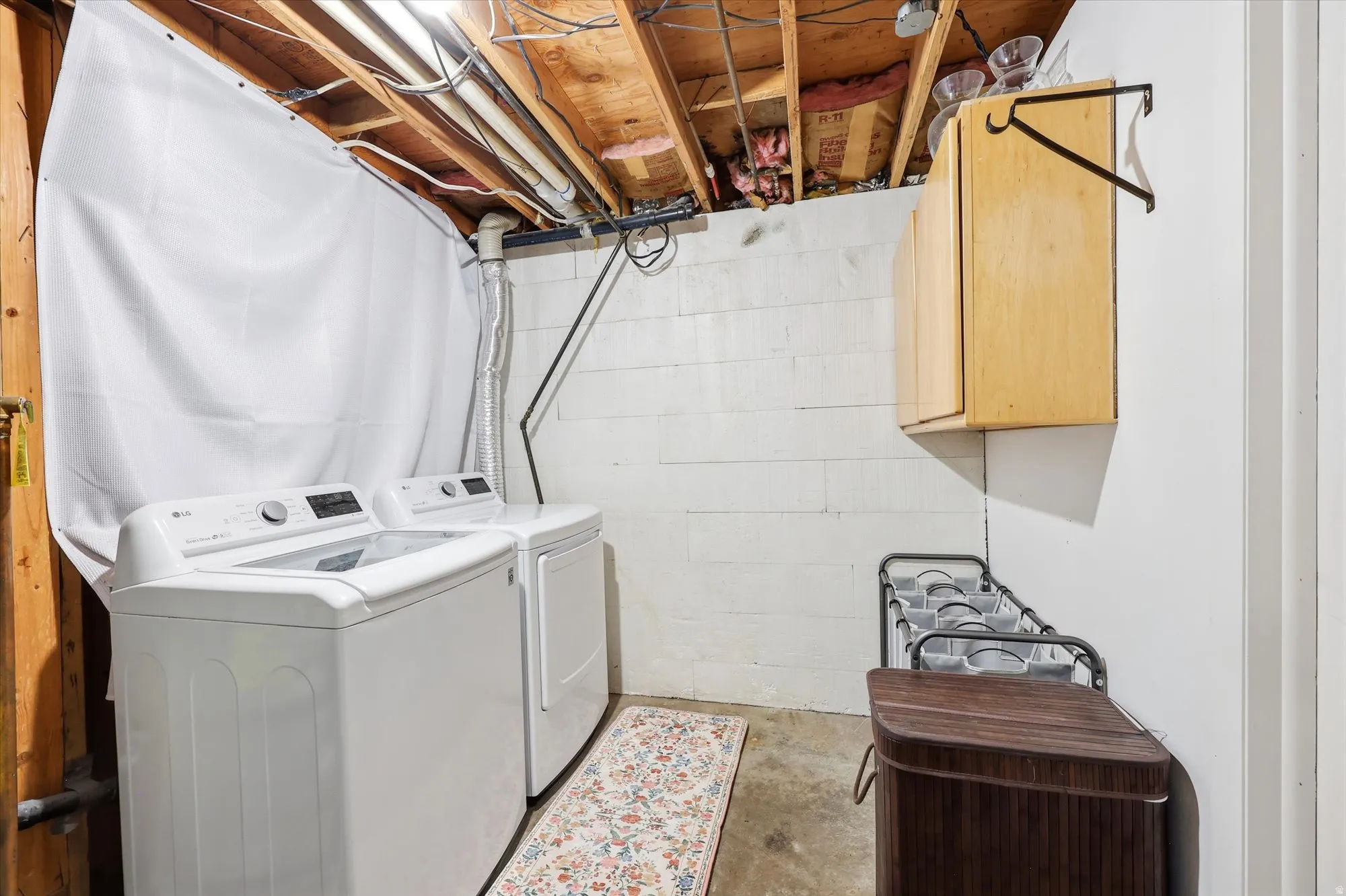 Dedicated laundry area featuring a white top-load washing machine and front-load dryer