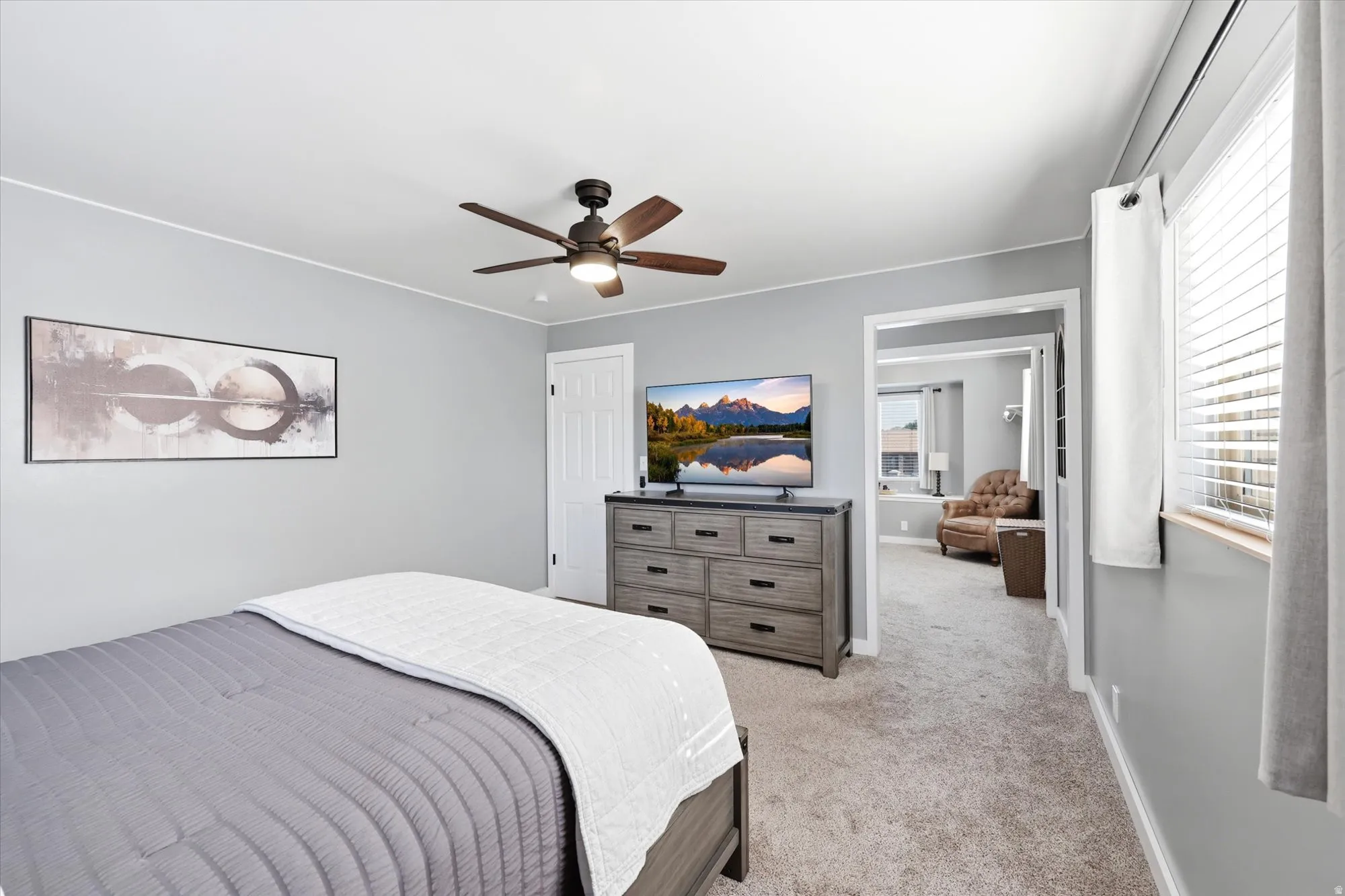 Bedroom featuring light gray walls and a ceiling fan with integrated lighting