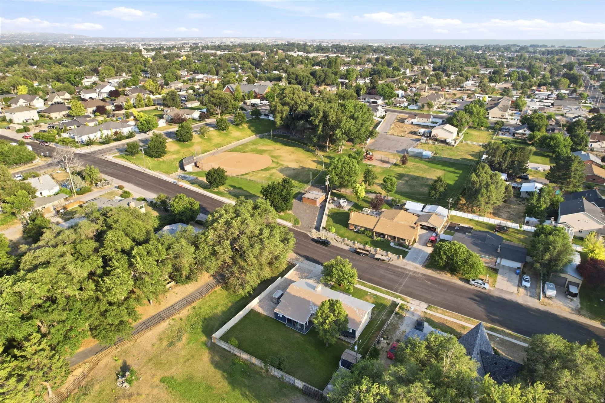Aerial perspective showcasing a residential neighborhood with mature trees and a clear sky
