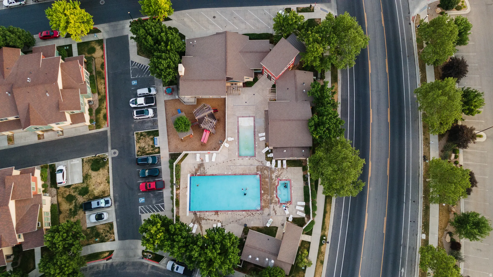 Community amenities featuring multiple swimming pools, a dedicated children's play area, and ample surface parking