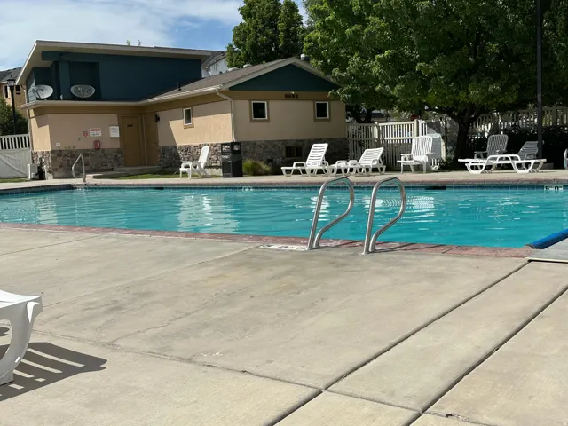 Outdoor swimming pool with concrete decking and metal handrails