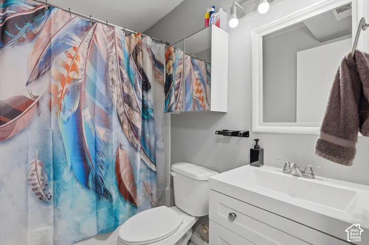 Contemporary bathroom featuring a white vanity with integrated sink, chrome faucet, and framed mirror