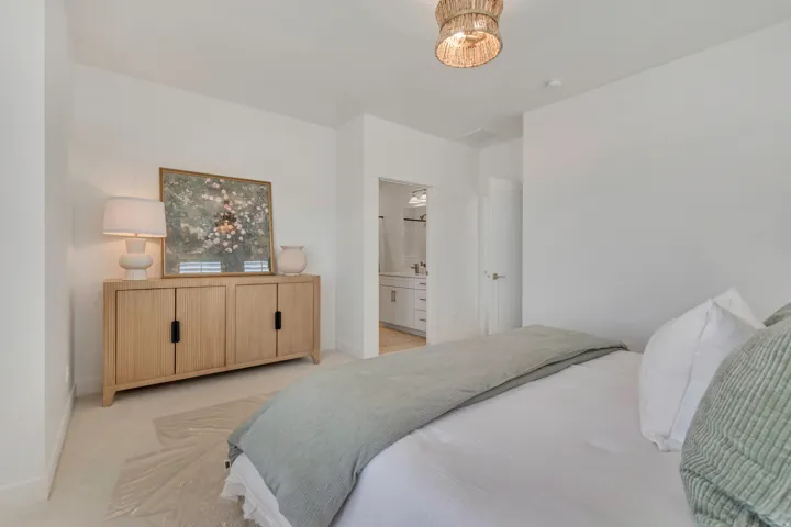 Bedroom featuring light wood-finish flooring and a woven ceiling light fixture