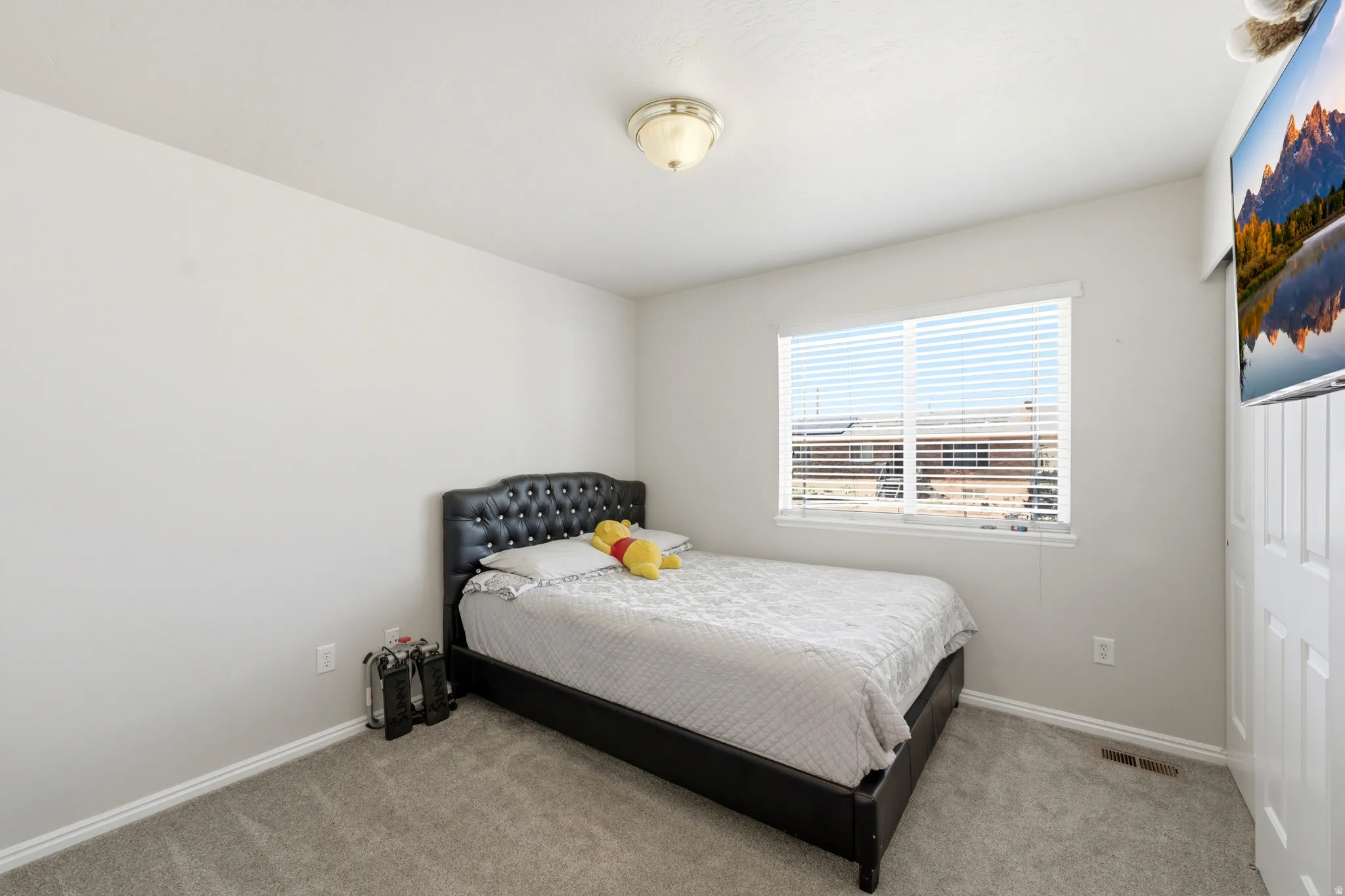 Carpeted room featuring a single window with blinds, white trim, a flush mount ceiling light fixture, and light-colored walls