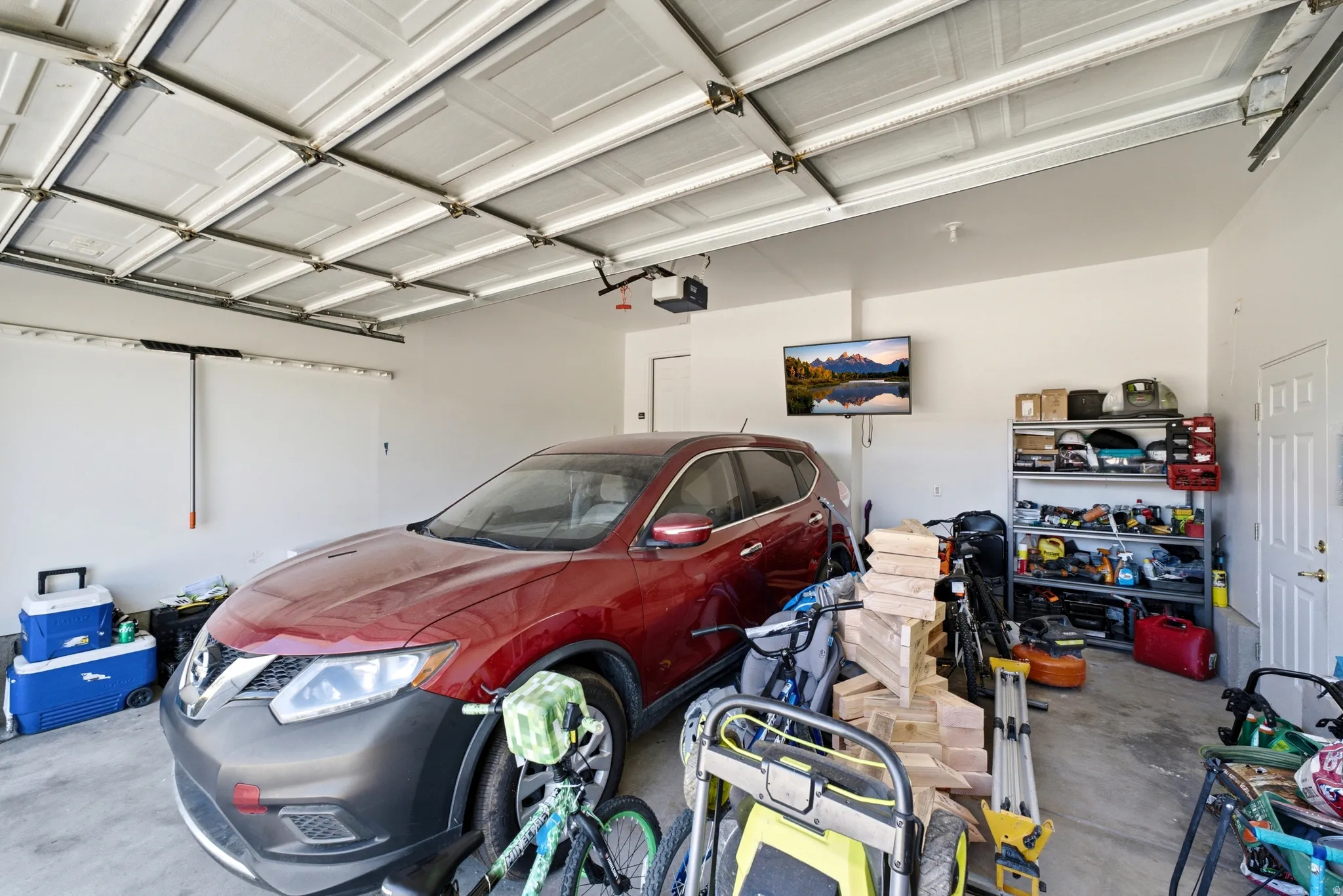Spacious garage featuring a white paneled door, light-colored walls, and a concrete floor