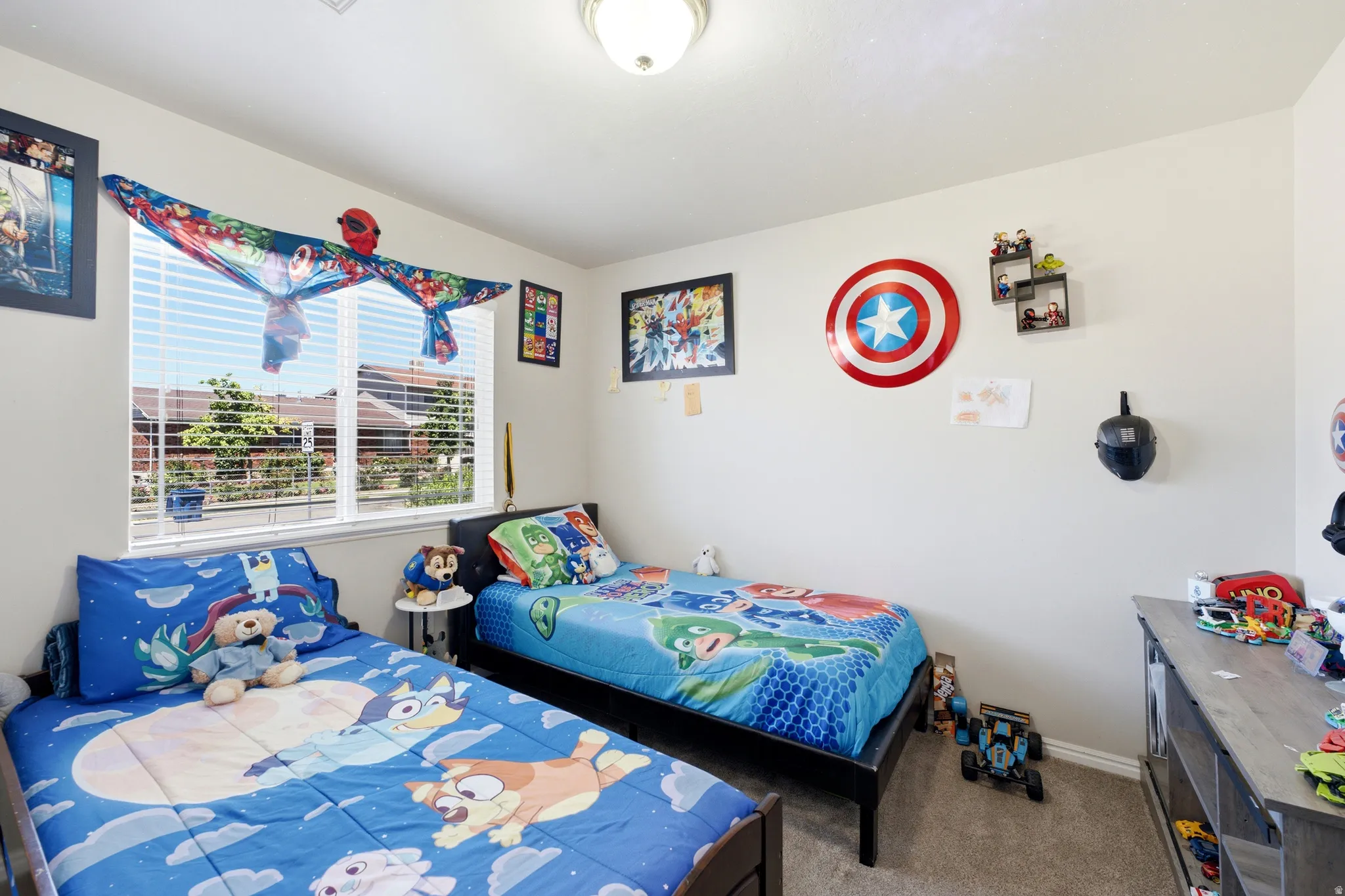 Bright room featuring a large window with horizontal blinds, neutral wall paint, and carpet flooring