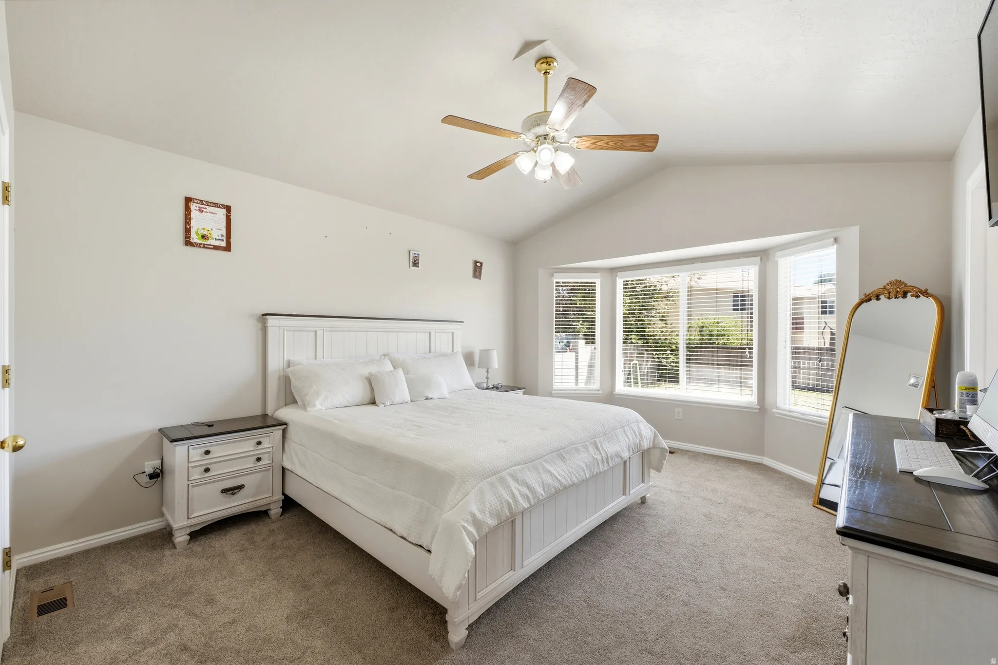 Carpeted room featuring a vaulted ceiling and a ceiling fan