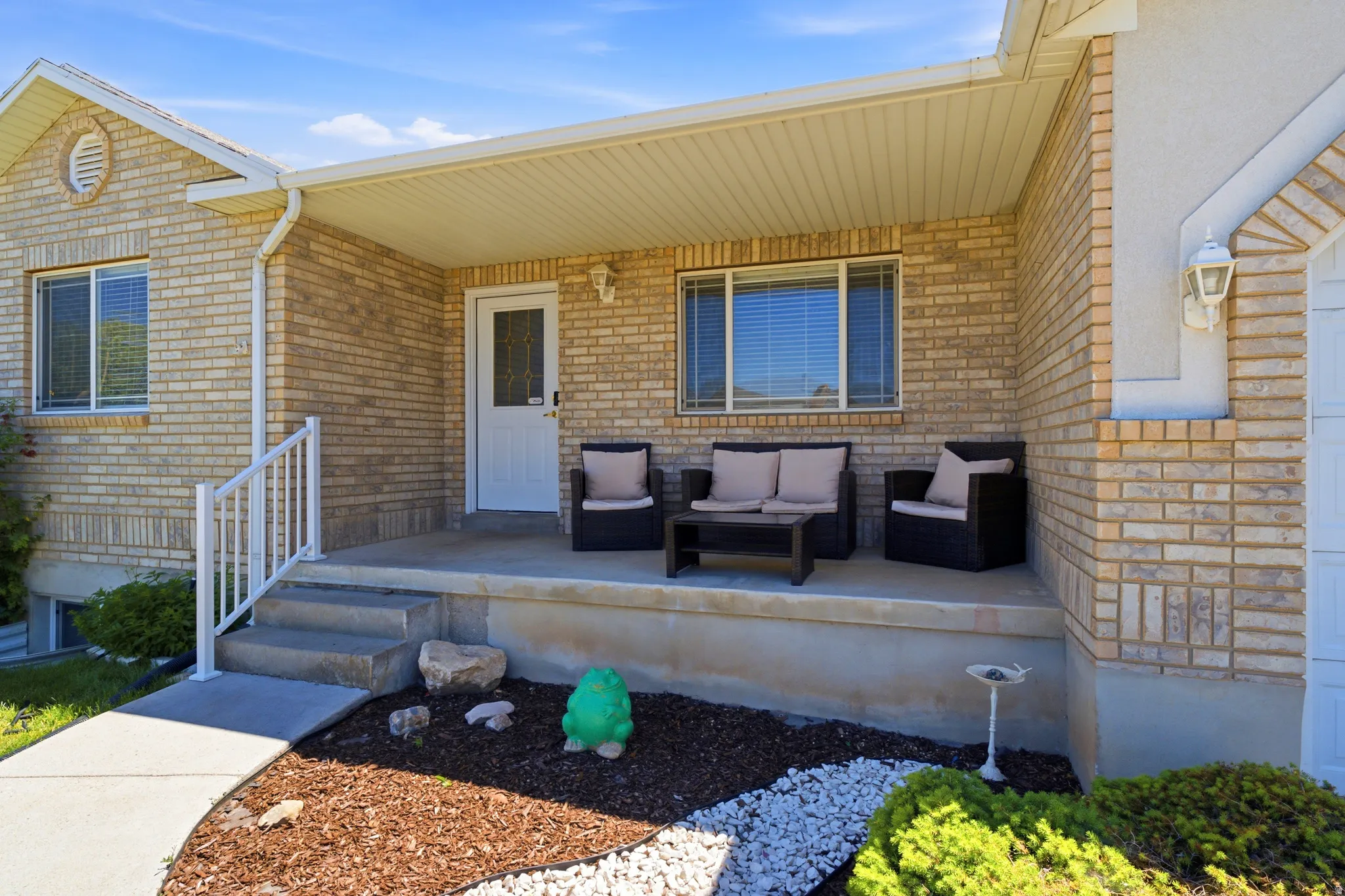 Brick exterior featuring a covered porch with concrete steps