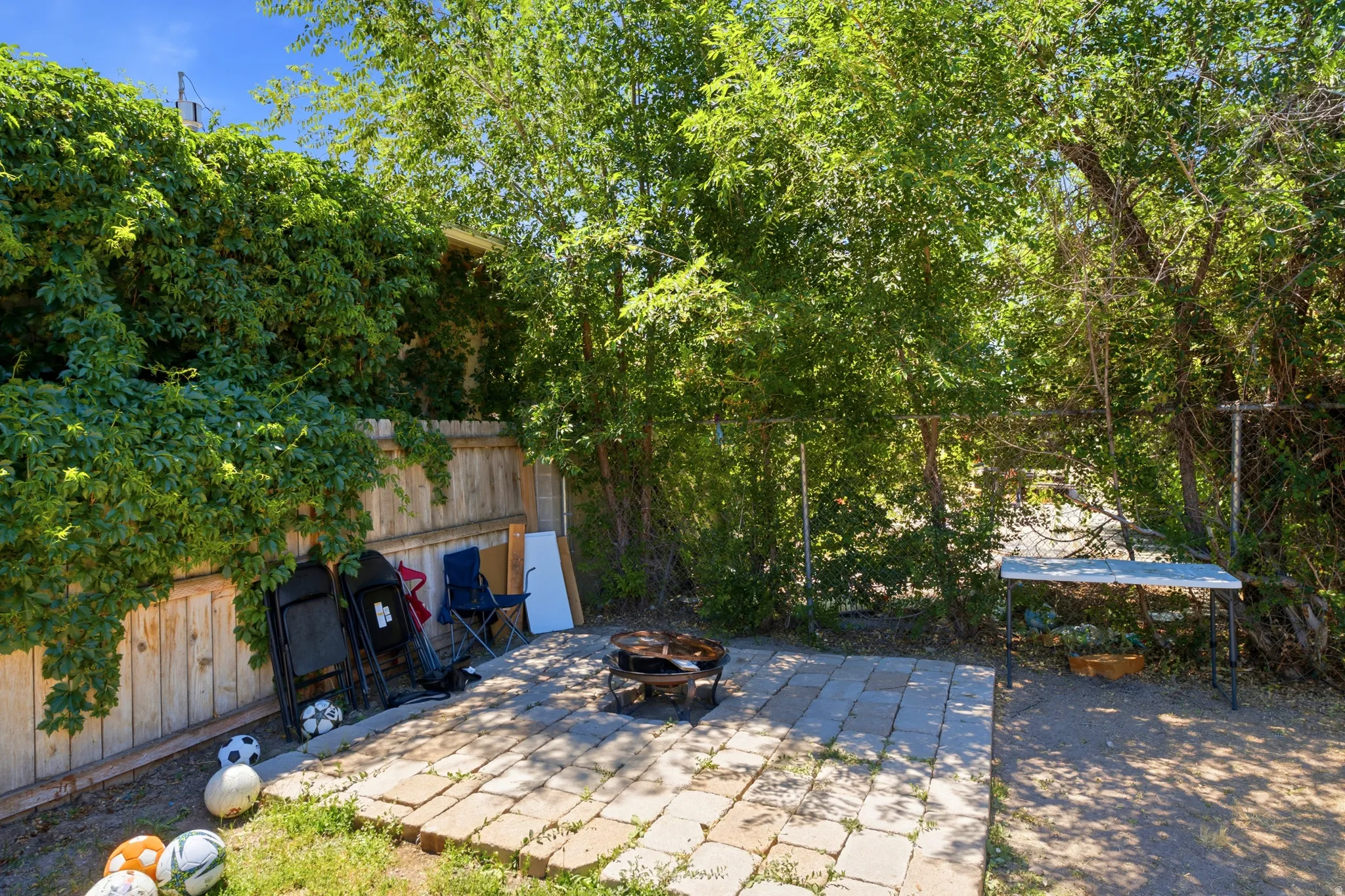 Expansive outdoor space featuring a paver patio with a built-in fire pit