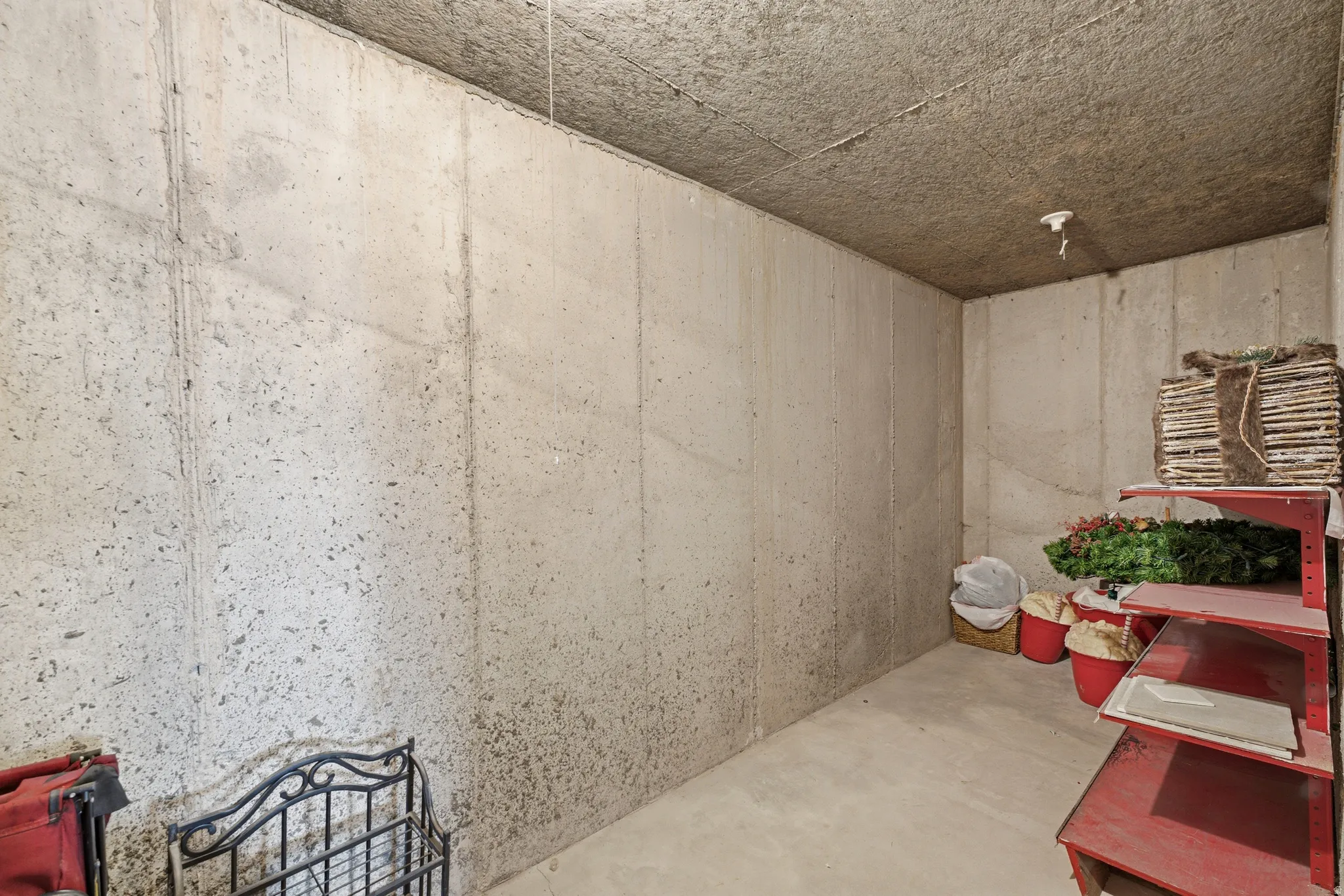 Unfinished basement area featuring concrete walls and flooring, with an exposed ceiling